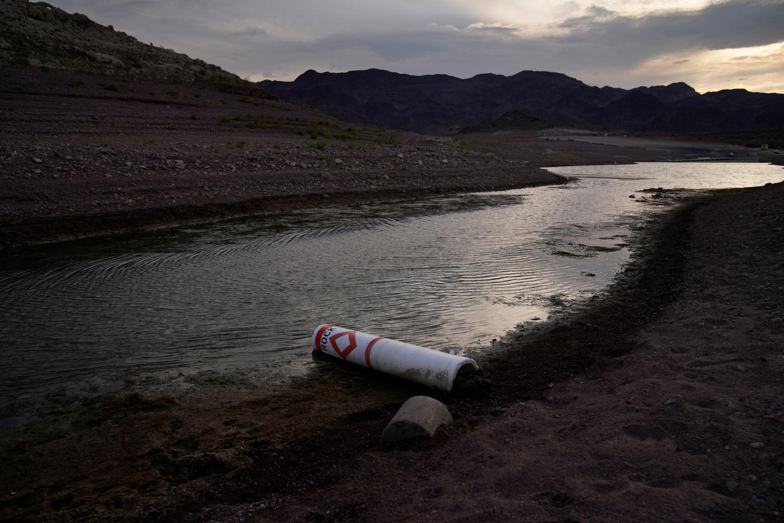A buoy once used to warn of a submerged rock rests on the ground along the waterline near a closed boat ramp on Lake Mead.  (Photo: John Locher, AP)