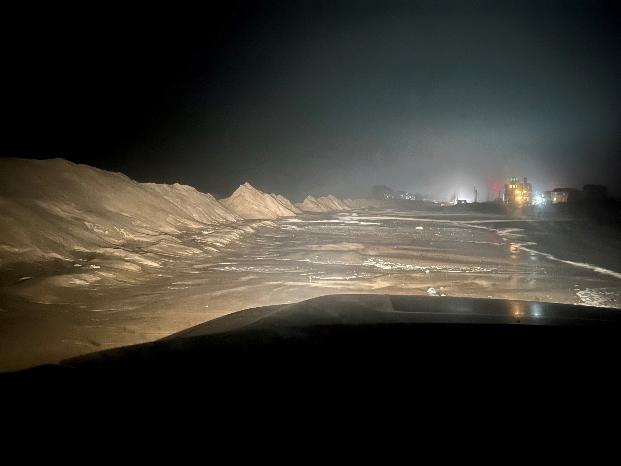 This nighttime photo shows high tides bringing water over sand dunes, causing road closures and threatening structures. (Photo: NC Department of Transportation, Fair Use)