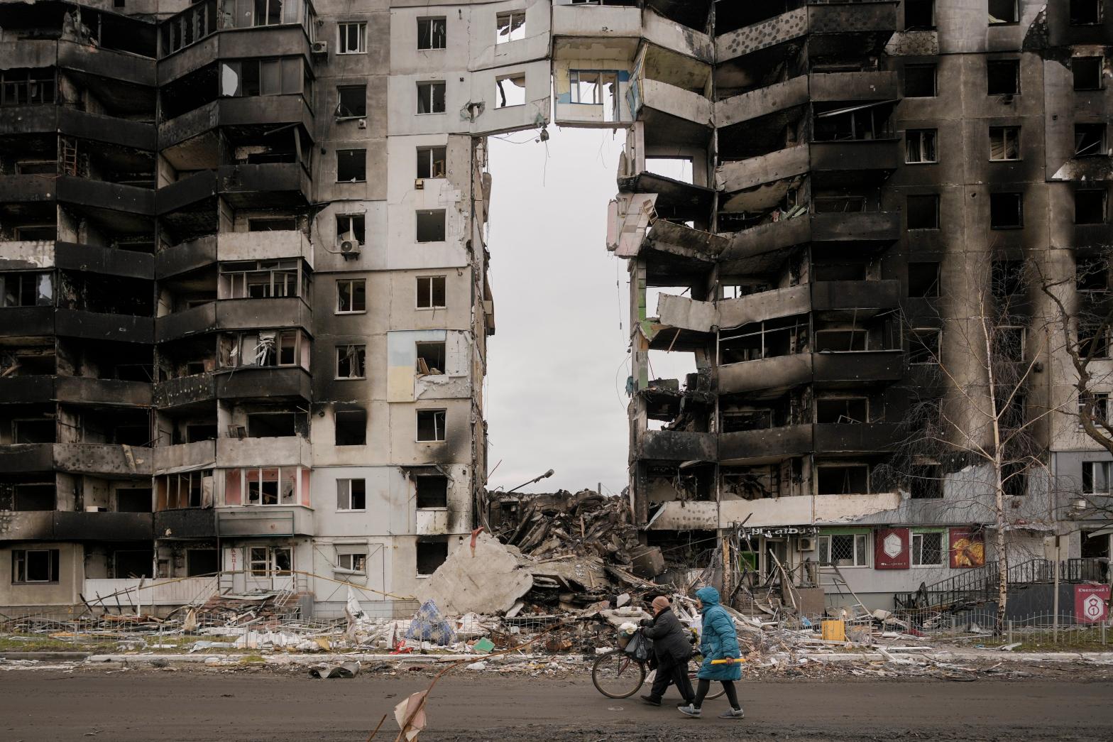 Women carrying food products walk by a destroyed apartment building in Borodyanka, on the outskirts of Kyiv, Ukraine in an area where officials said there were numerous examples of Russian war crimes. (Photo: Vadim Ghirda, AP)