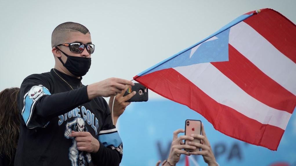 Bad Bunny waves a flag during a 2019 national strike demanding Puerto Rico's Governor Ricardo Rossello resignation.  (Photo: ERIC ROJAS/AFP, Getty Images)