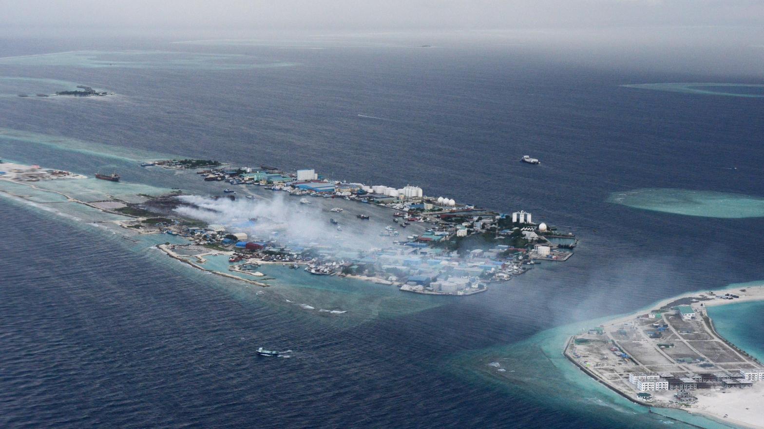 In this September 2013 photo, smoke from trash fires on Thilafushi billows out over the ocean. (Photo: Roberto Schmidt/AFP, Getty Images)
