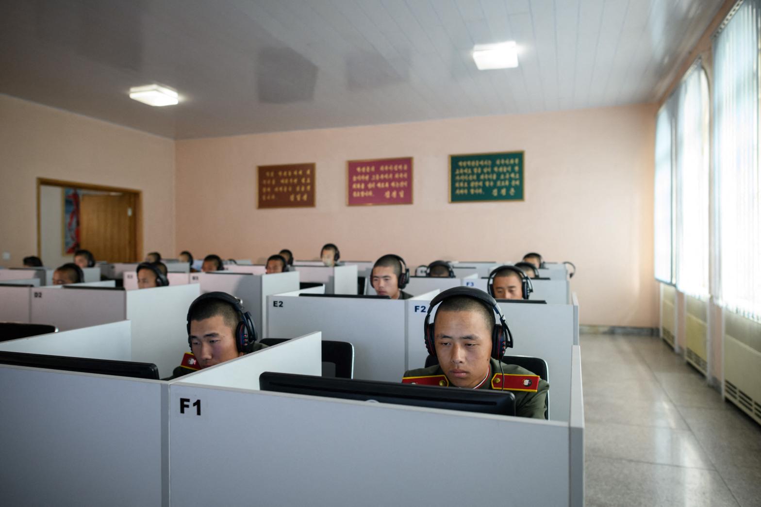 Students wearing Korean People's Army uniforms sit before computer screens as they attend a class at the Mangyongdae Revolutionary School outside Pyongyang in 2018. U.S. officials claim that North Korea has focused on training workers in computer skills before using them to infiltrate companies as undercover IT professionals. (Photo: ED JONES/AFP, Getty Images)