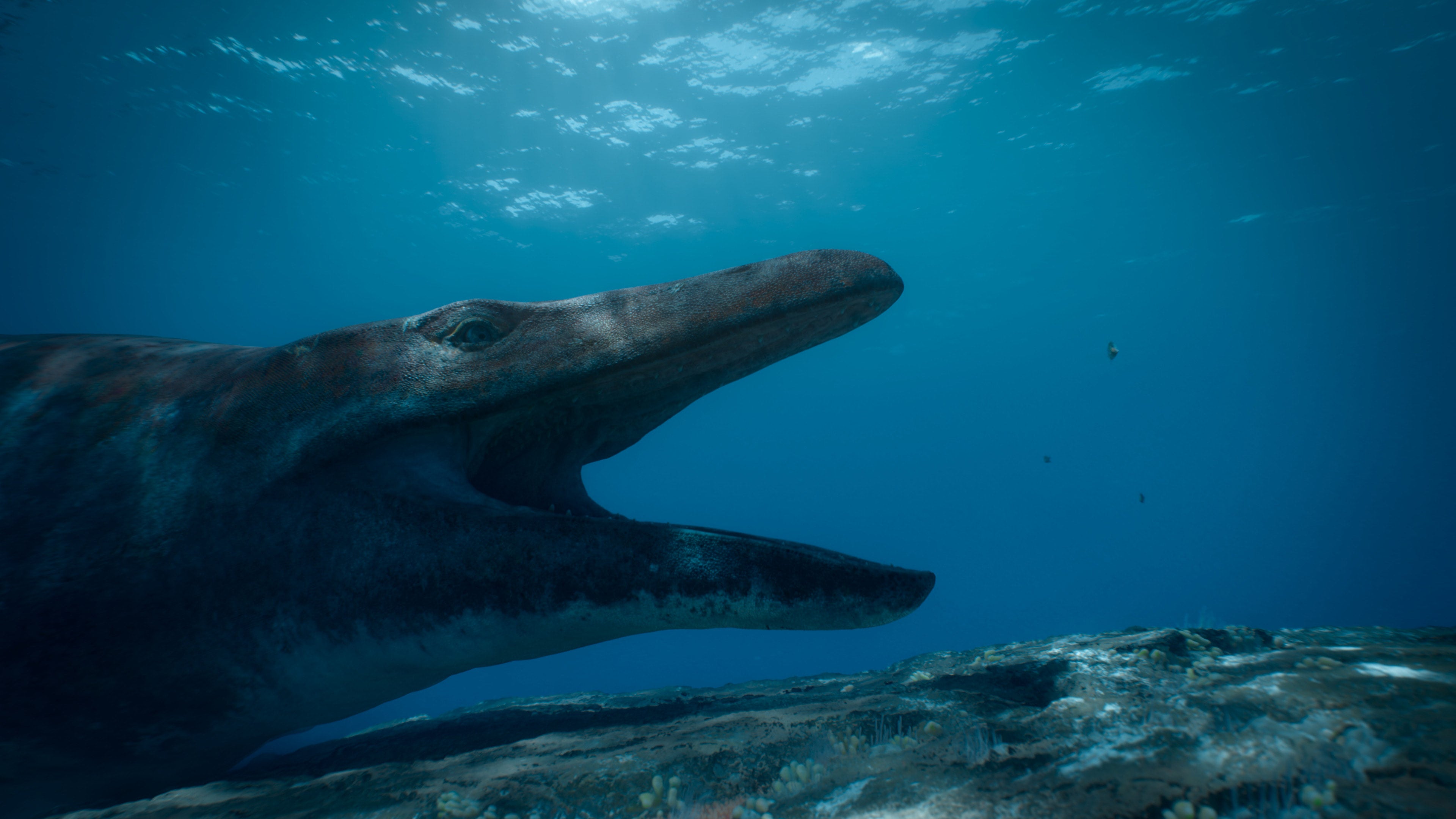 Mosasaurus on a reef system, mouth wide. (Image: Apple)