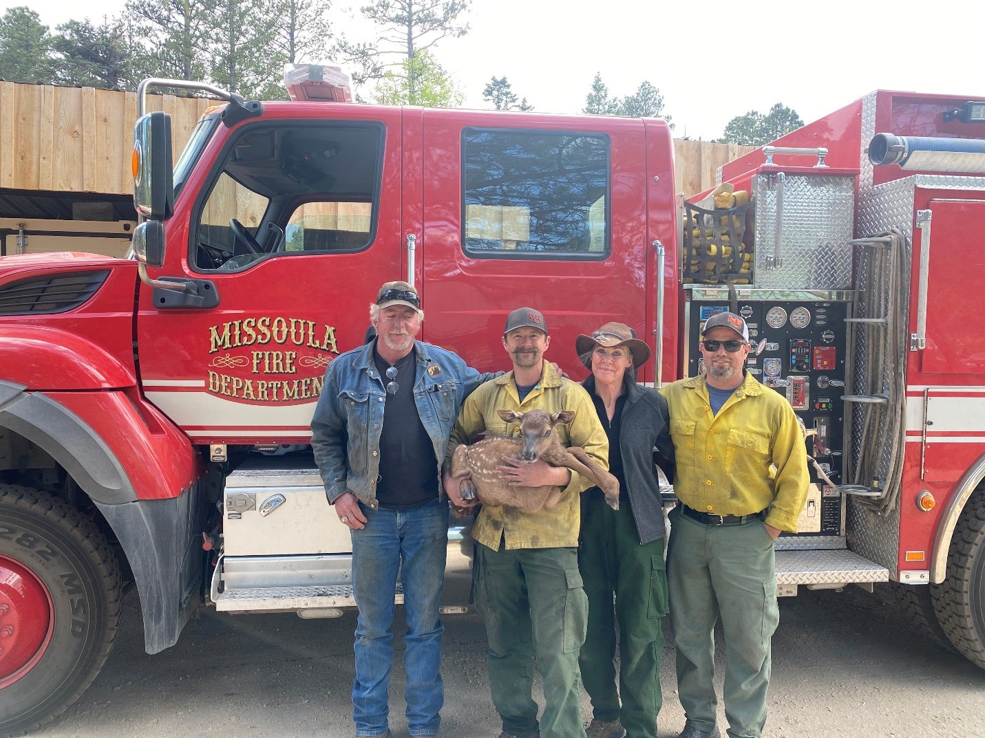 Cinder with firefighters and ranchers Lisa and Carl Bartley. (Photo: USDA Forest Service)