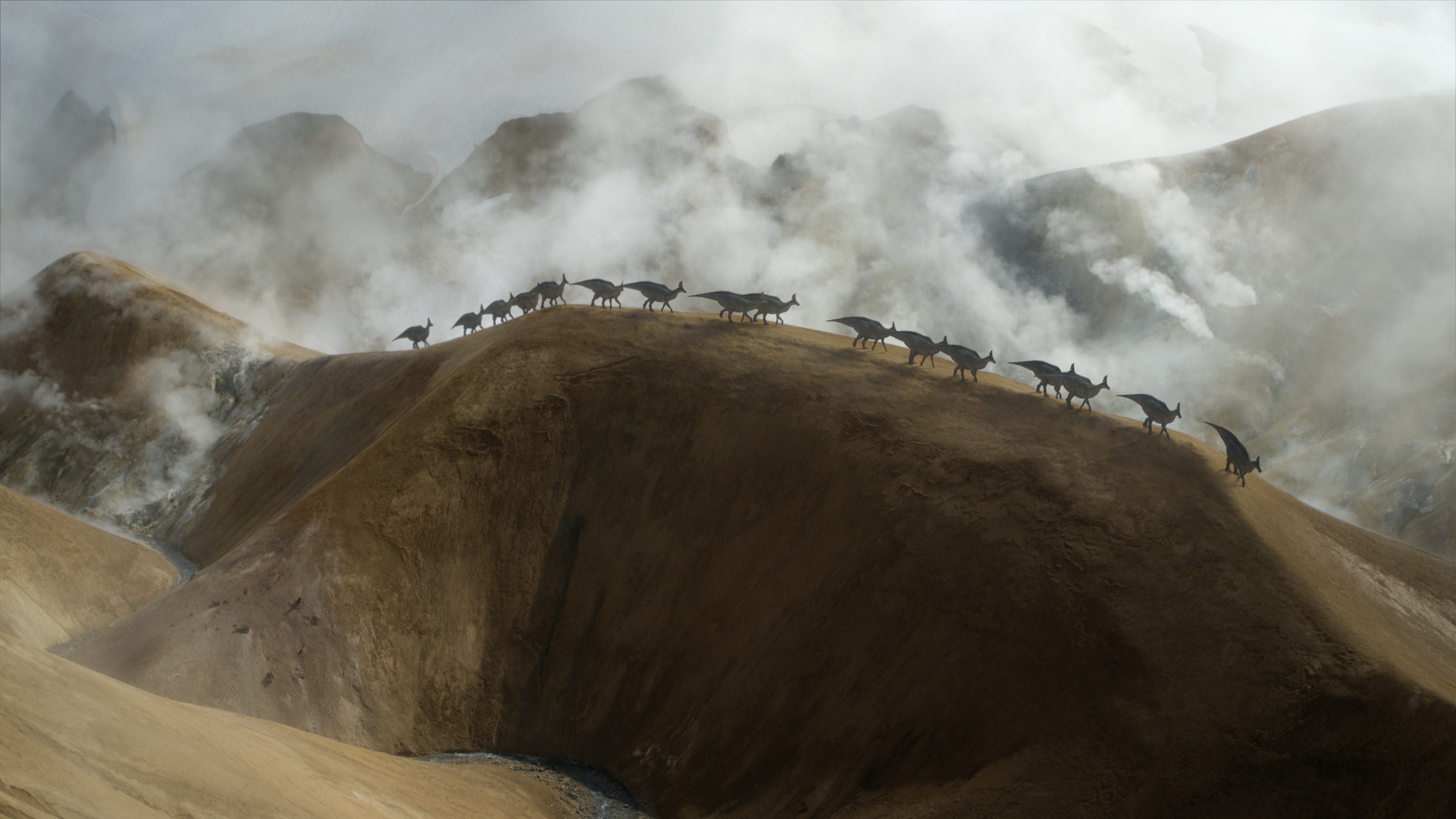 A herd of Olorotitans scaling a large dune. (Image: Apple)