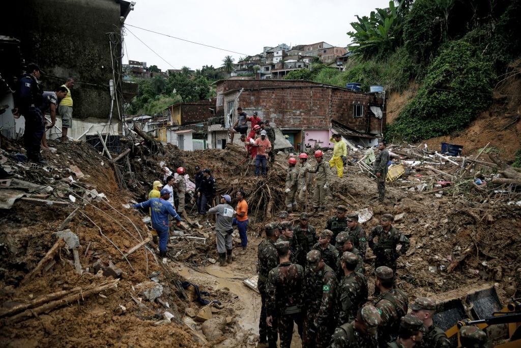 Soldiers, firefighters, and residents search for victims a day after a landslide in the community Jardim Monte Verde in Brazil. (Photo: Brenda ALCANTARA / AFP, Getty Images)