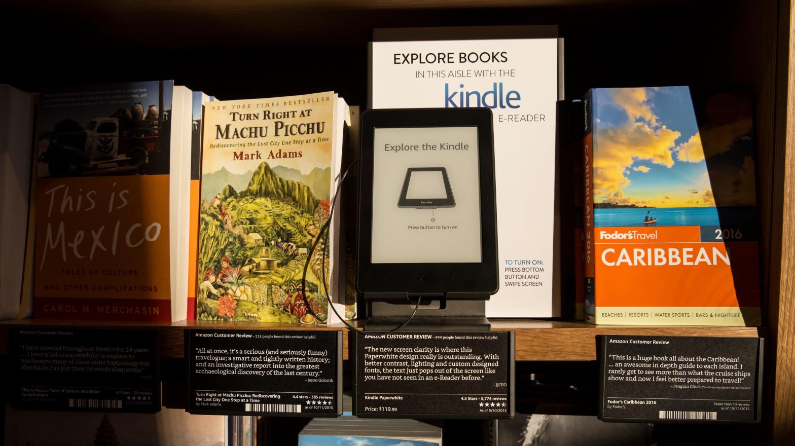 Books are displayed along side an Amazon Kindle device, which offers previews of those same books on nearby shelves at the Amazon Books store on November 4, 2015 in Seattle, Washington.  (Photo: Stephen Brashear, Getty Images)