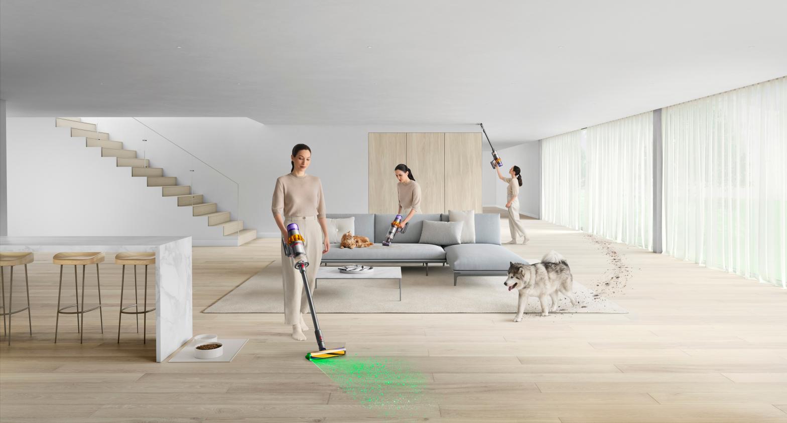 A woman, seemingly in three places at once, cleans up after dirty pets in a large, relatively unfurnished space using Dyson attachments on a V15