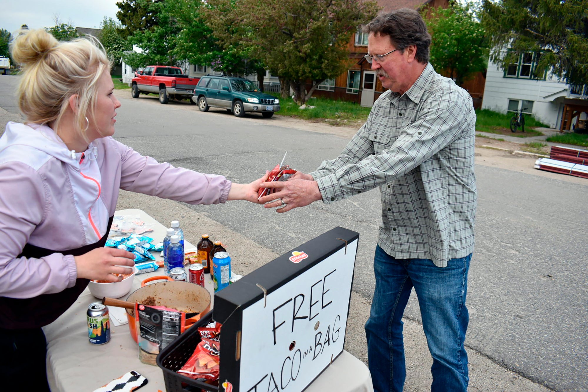Chandler Peabody, left, gives a free meal to Perry Roberts near a  flood-damaged neighbourhood in Red Lodge, Mont., Tuesday, June 14, 2022.  Roberts' basement was inundated, ruining his hot water heater and  furnace.  (Photo: Matthew Brown, AP)