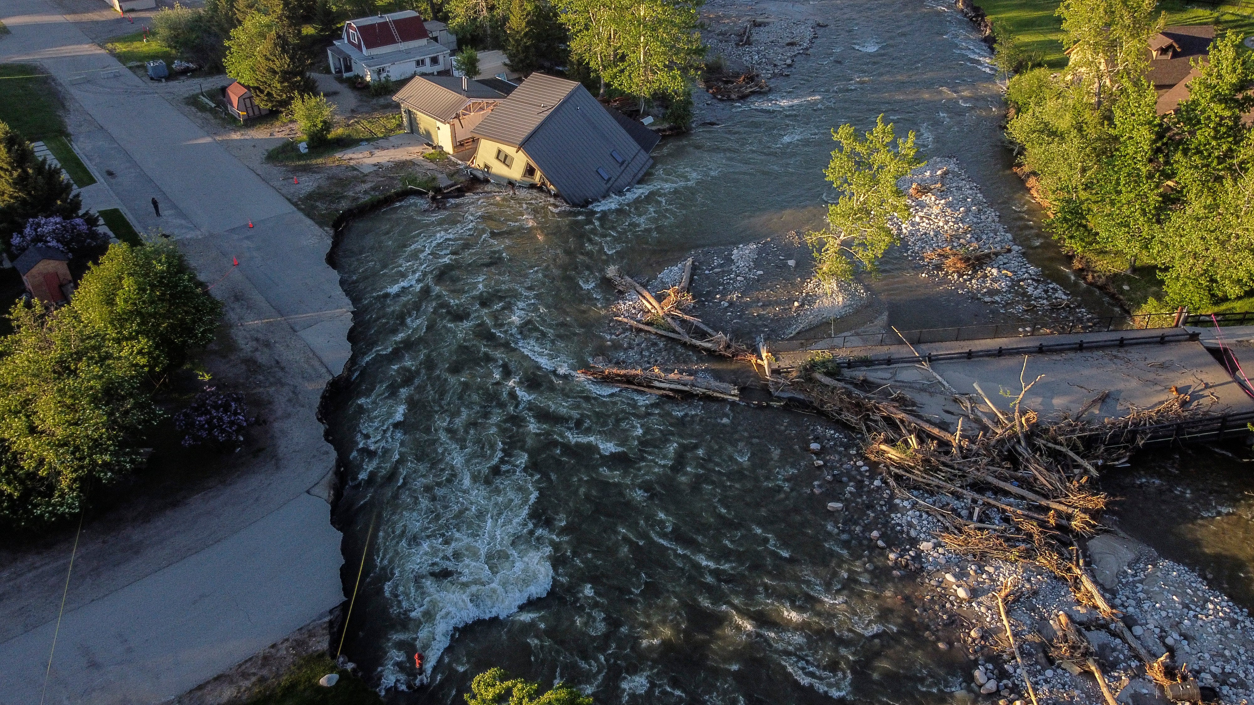 A house sits in Rock Creek after floodwaters washed away a road and a bridge in Red Lodge, Mont., Wednesday, June 15, 2022. (Photo: David Goldman, AP)