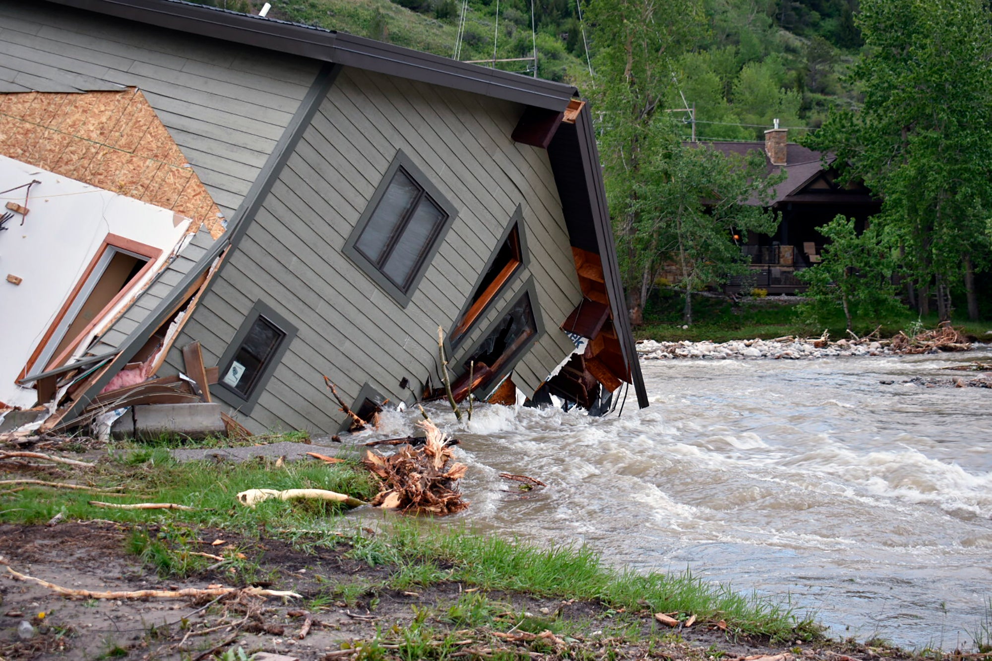 A house that was pulled into Rock Creek in Red Lodge, Mont., by raging floodwaters is seen Tuesday, June 14, 2022. (Photo: Matthew Brown, AP)