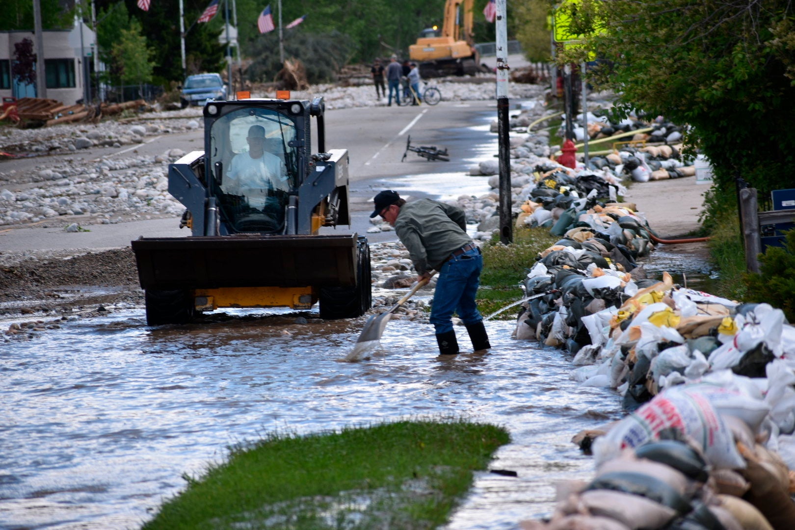 Residents of Red Lodge, Montana, are seen clearing mud, water and debris  from the small city's main street on Tuesday, June 14, 2022, after  flood waters courses through a residential area with hundreds of homes. (Photo: Matthew Brown, AP)