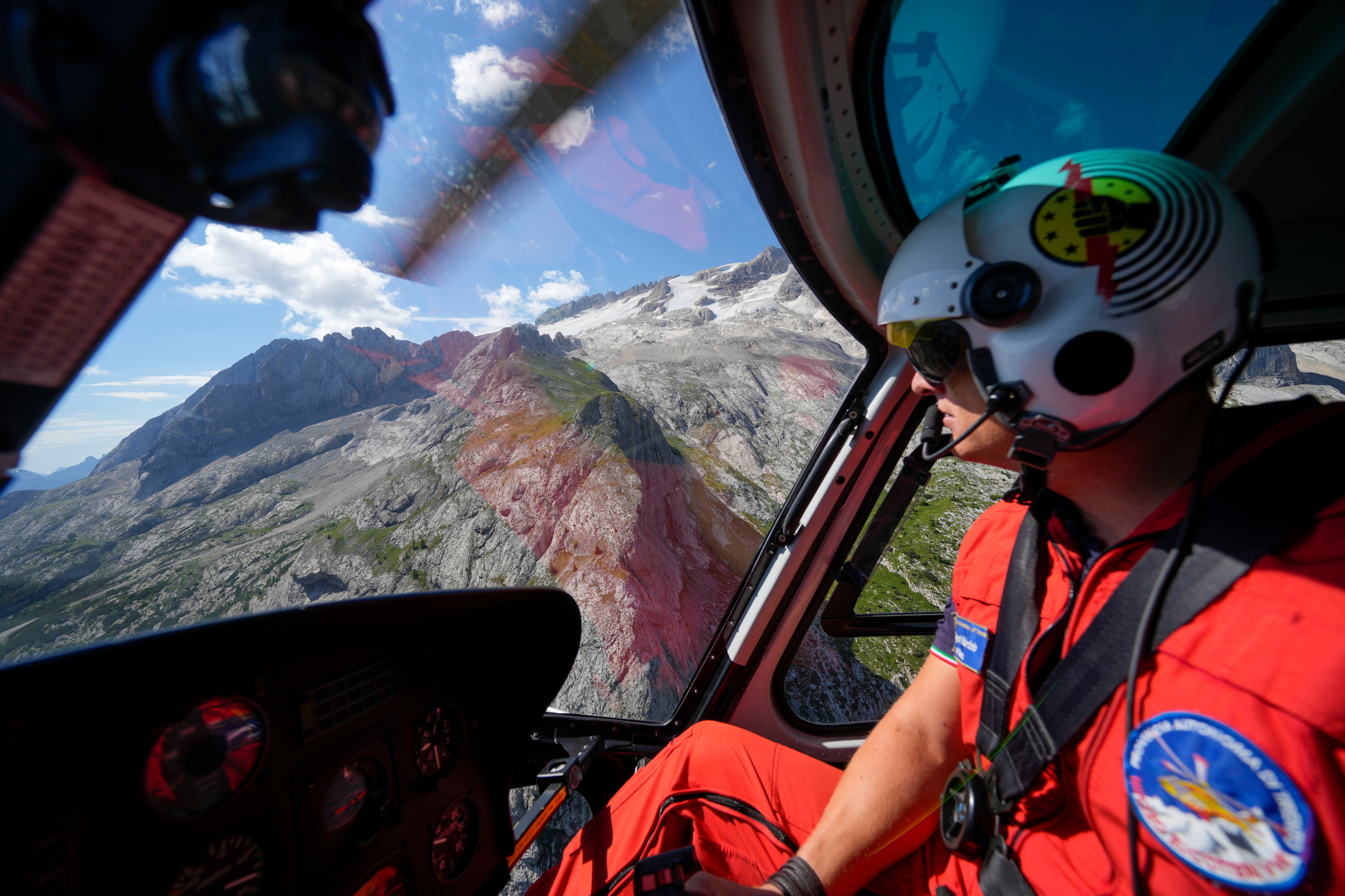 A rescuer pilots a helicopter to look for survivors. (Photo: Luca Bruno, AP)