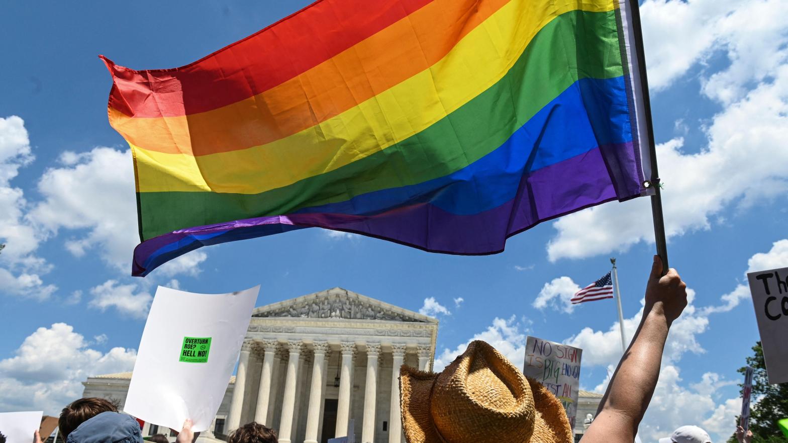 Protesters wave a Pride flag in front of the Supreme Court a day after the Court struck down Roe v. Wade. (Photo: Roberto Schmidt/AFP, Getty Images)