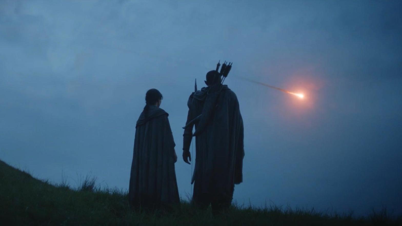 Arondir (Ismael Cruz Cordova) and Bronwyn (Nazanin Bonidai) watch something in the sky in a new trailer for The Lord of the Rings: The Rings of Power. (Screenshot: Prime Video)