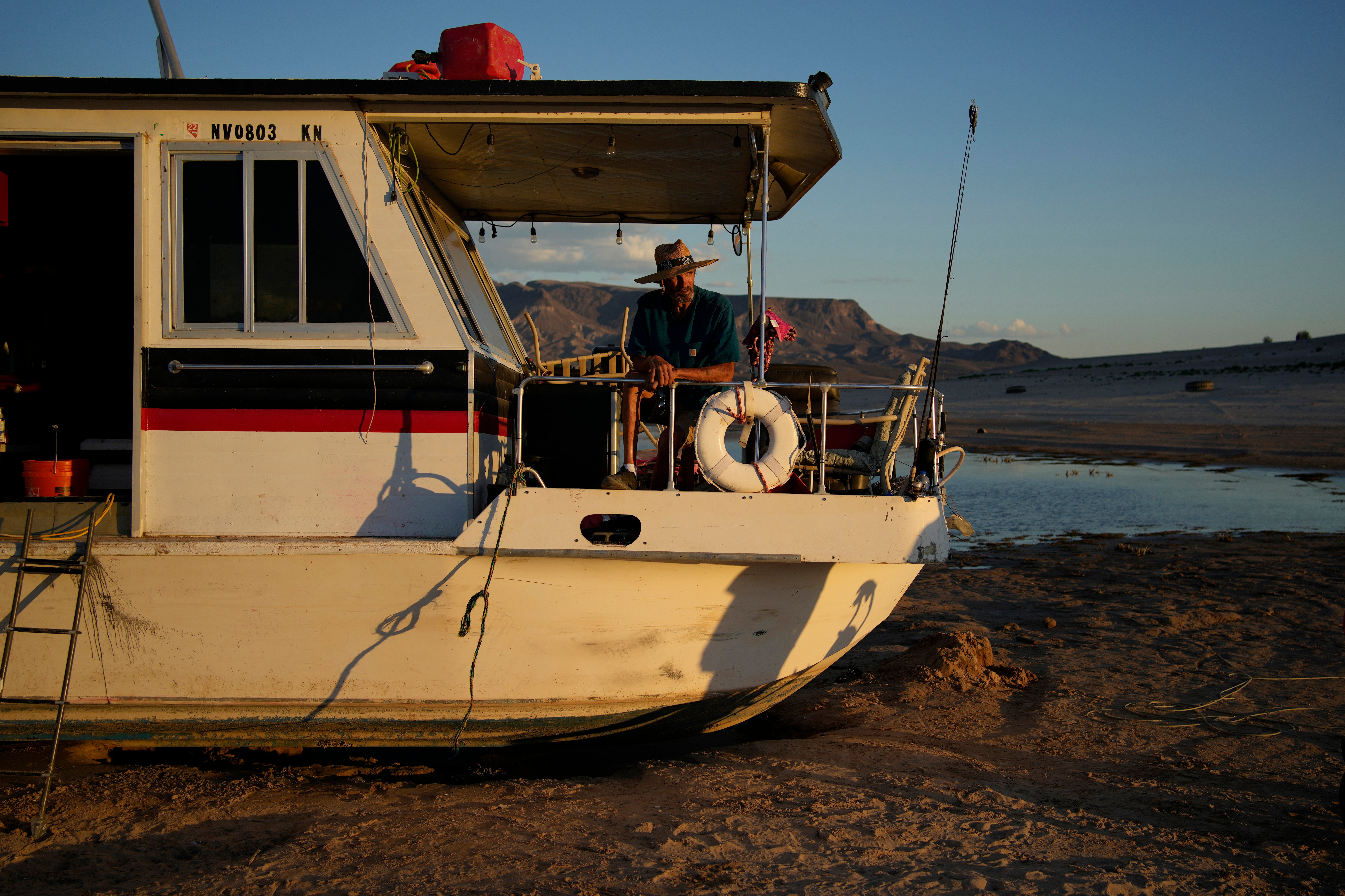 A man sits on his stuck houseboat in Lake Mead. (Photo: John Locher, AP)