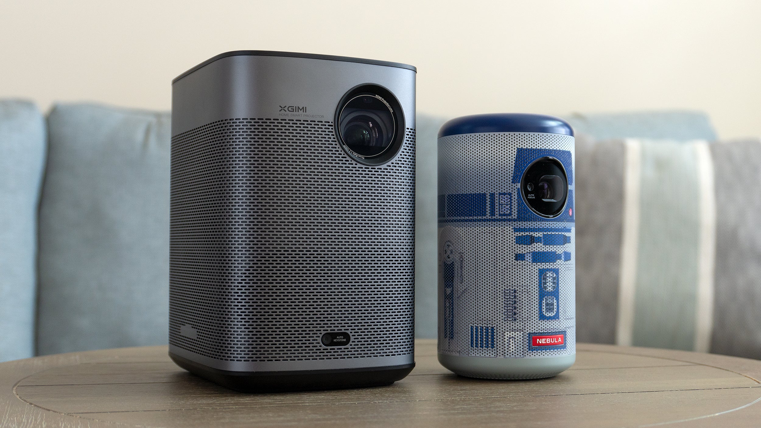 The XGIMI Halo+ (left) is quite a bit larger than the Anker Nebula Capsule II R2-D2 Edition projector (right) which itself is only slightly larger than a soda can. (Photo: Andrew Liszewski | Gizmodo)