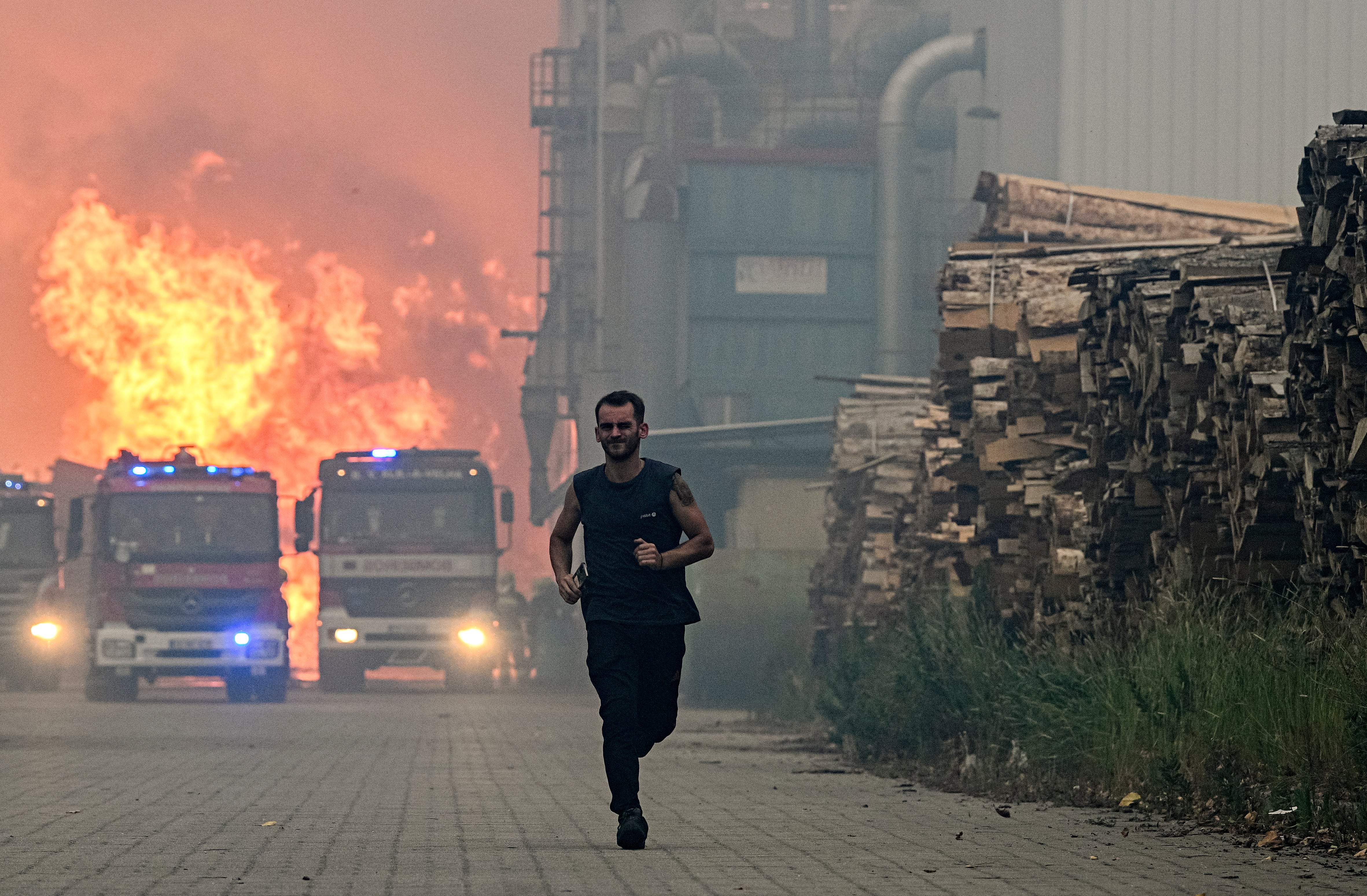 A lumber factory worker runs from a fire that hit his factory in Albergaria a Velha, Portugal on July 13, 2022.  (Photo: Octavio Passos, Getty Images)