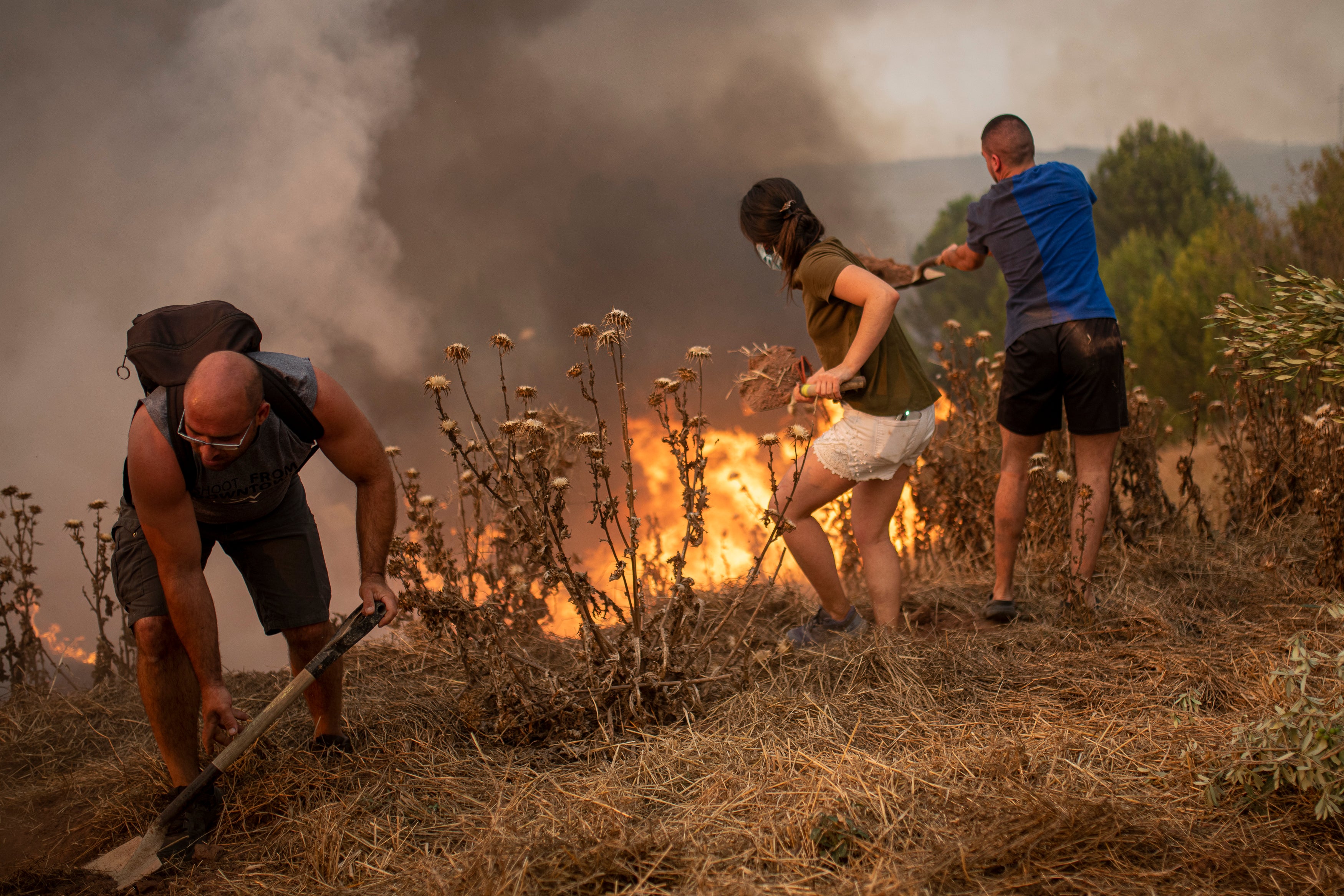 Residents of Sant Fruitós del Bages, Catalonia, Spain work together to extinguish a wildfire on July 17, 2022. (Photo: Lorena Sopêna / Europa Press, AP)