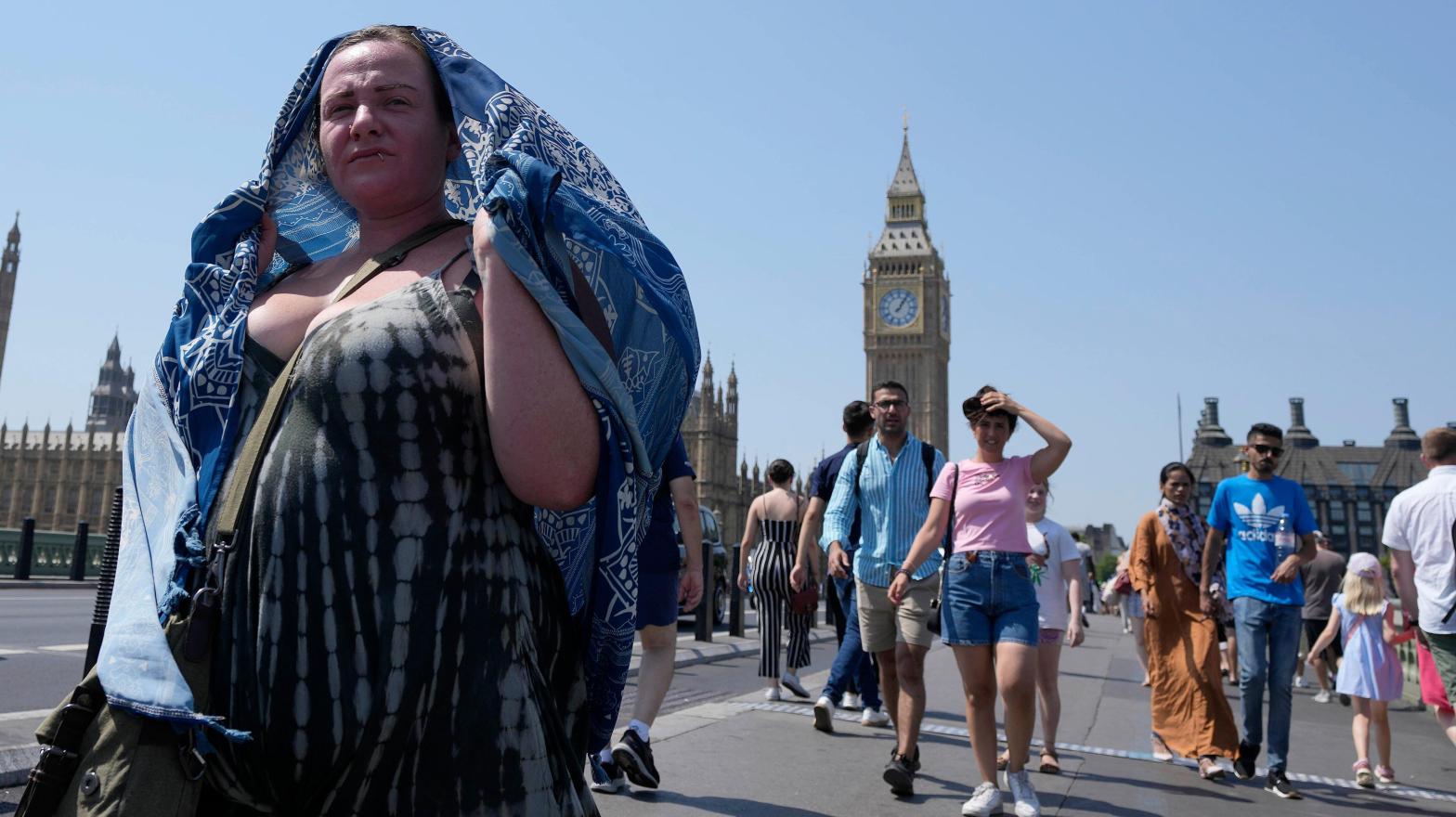 Pedestrians try to keep themselves cool in London on Tuesday. (Photo: Frank Augstein, AP)