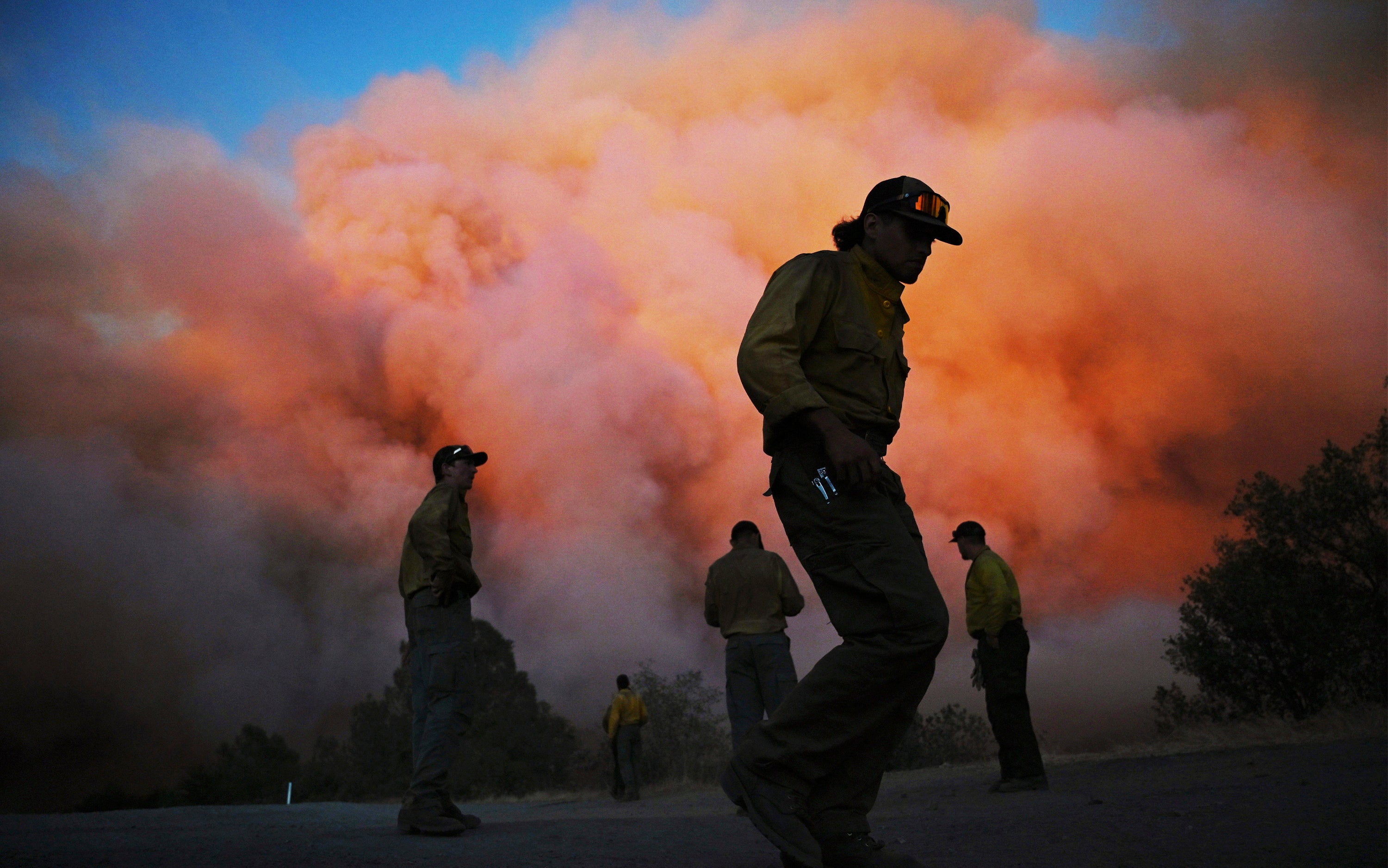 U.S. Forest firefighters stand watching a wildfire called the Oak Fire burn east of Midpines in Mariposa County, Calif., Friday, July 22, 2022 (Photo: Eric Paul Zamora/The Fresno Bee, AP)