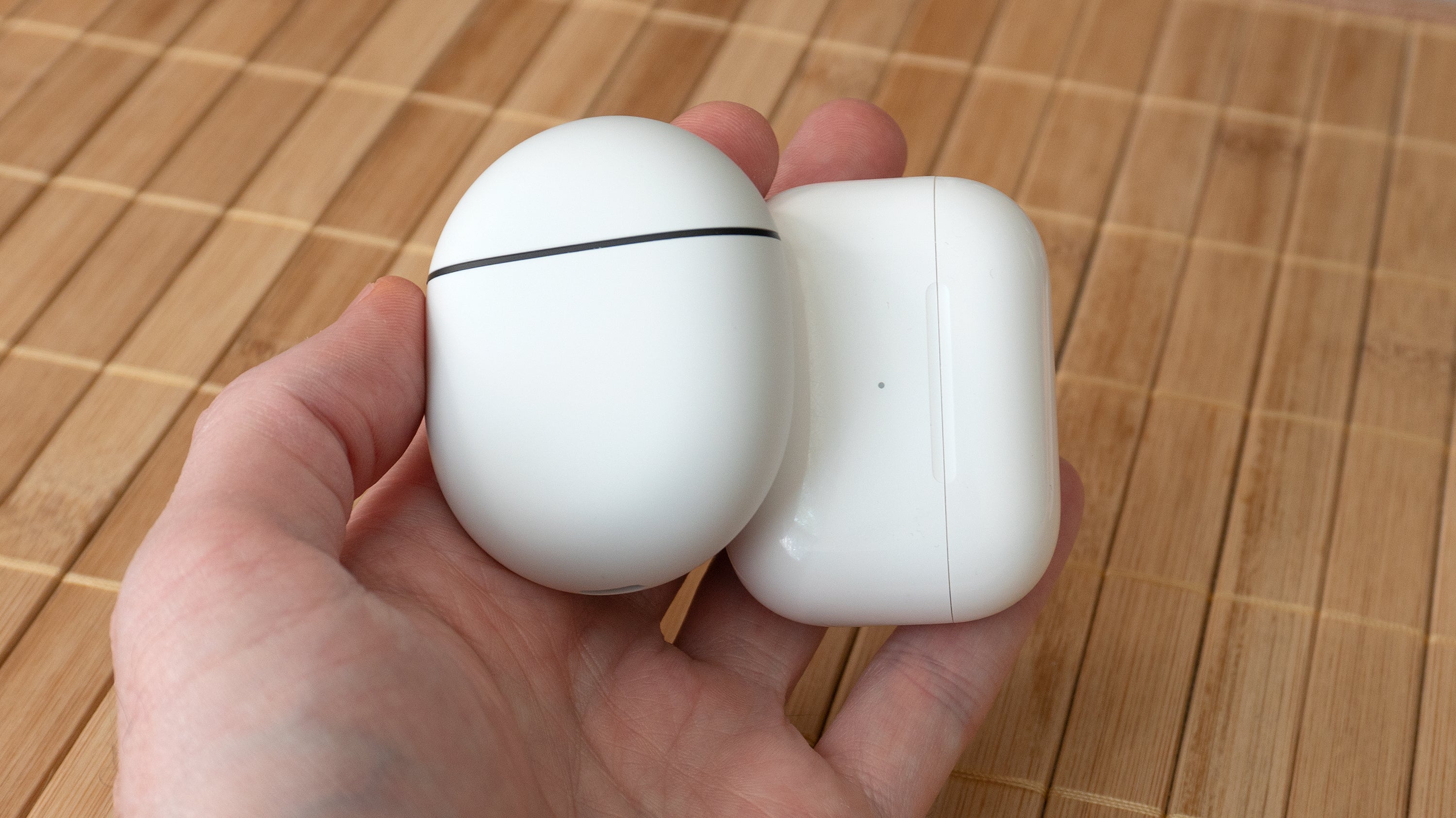 The Pixel Buds Pro charging case (left) next to the AirPods Pro charging case (right). (Photo: Andrew Liszewski | Gizmodo)