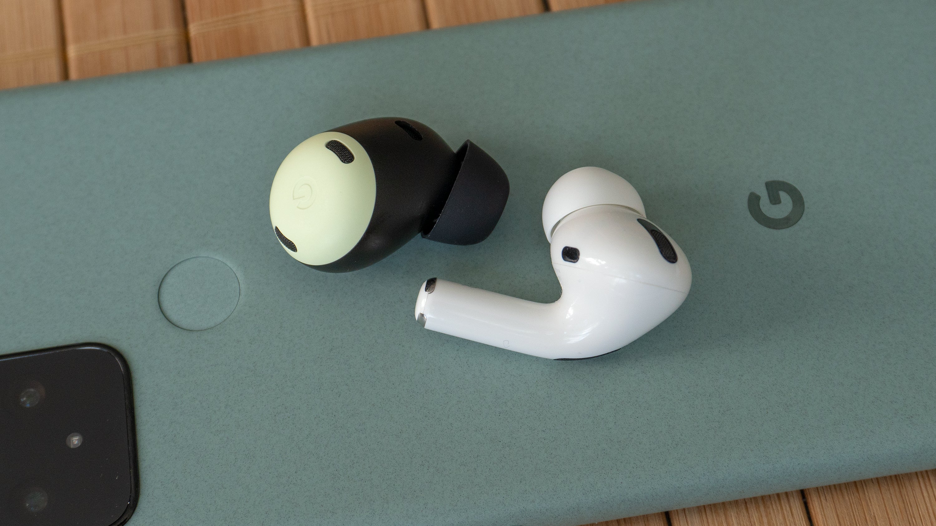 The Pixel Buds Pro (left) are very compact and easy to comfortably wear, and forego the stem design used for the AirPods Pro (right). (Photo: Andrew Liszewski | Gizmodo)