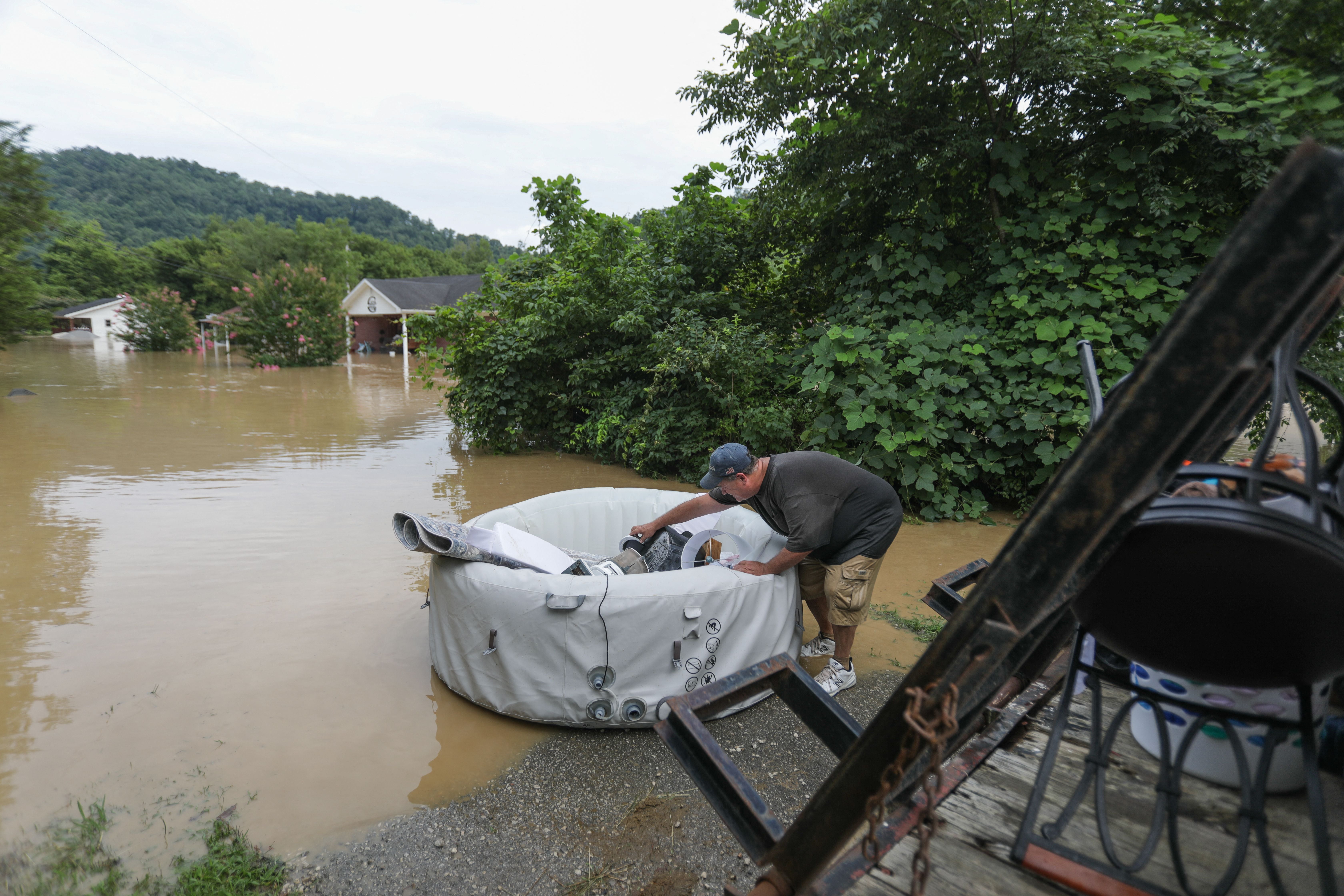 A man loads possessions into a floating device into waters around his home in Jackson.  (Photo: Leandro Lozada / AFP, Getty Images)
