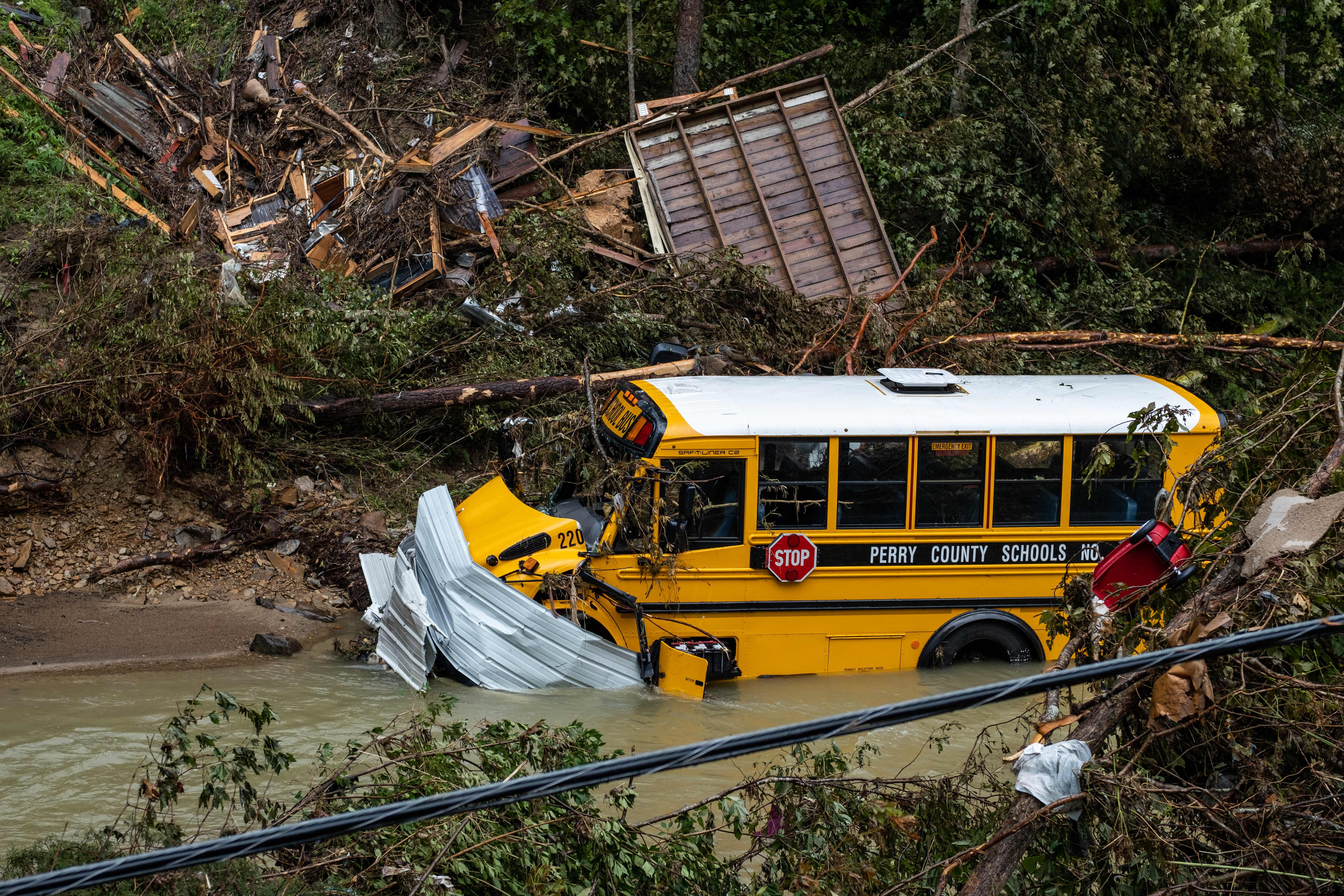 A Perry County school bus, along with other debris, sits in a creek near Jackson, Kentucky, on July 31, 2022. (Photo: Seth Herald / AFP, Getty Images)