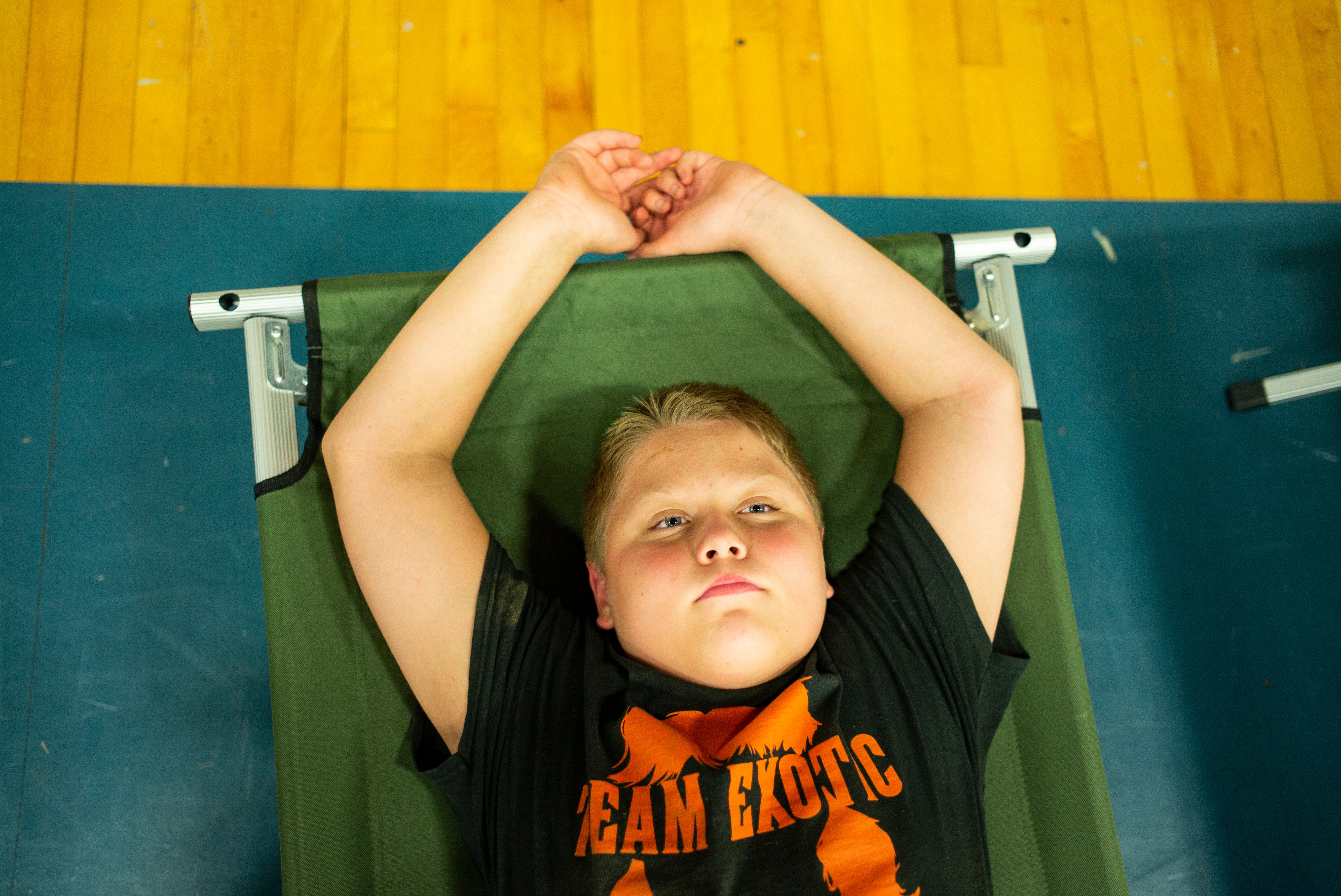 Zachary Stivers, 11, of Lost Creek, Kentucky, rests on a cot in the  Hazard Community & Technical College, where survivors of the major  flooding in Eastern Kentucky are being taken for shelter on July 28,  2022 in Breathitt County, Kentucky.  (Photo: Michael Swensen, Getty Images)