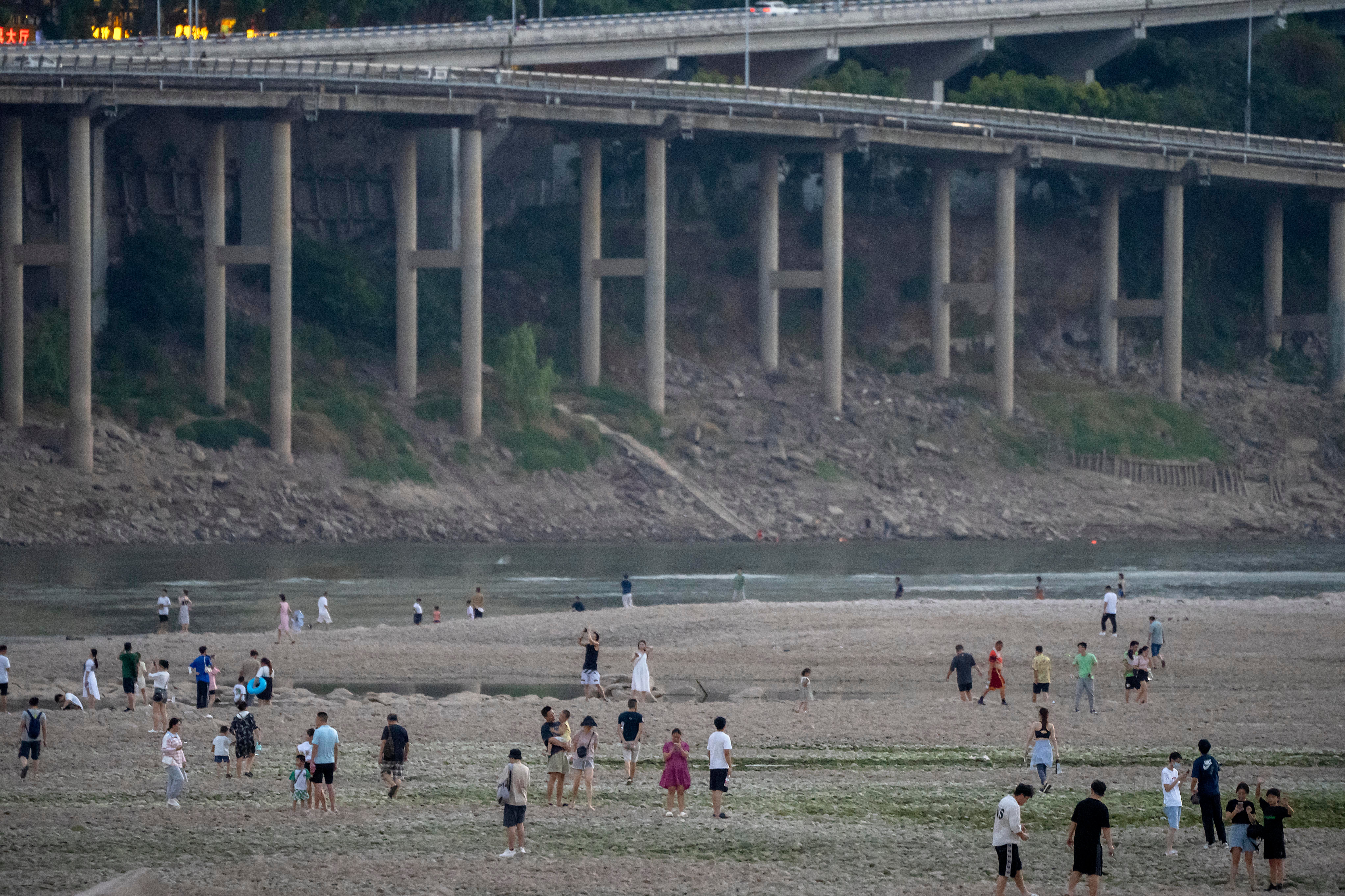 People walk in the dry riverbed of the Jialing River, a tributary of the Yangtze, on August 20. (Photo: Mark Schiefelbein, AP)