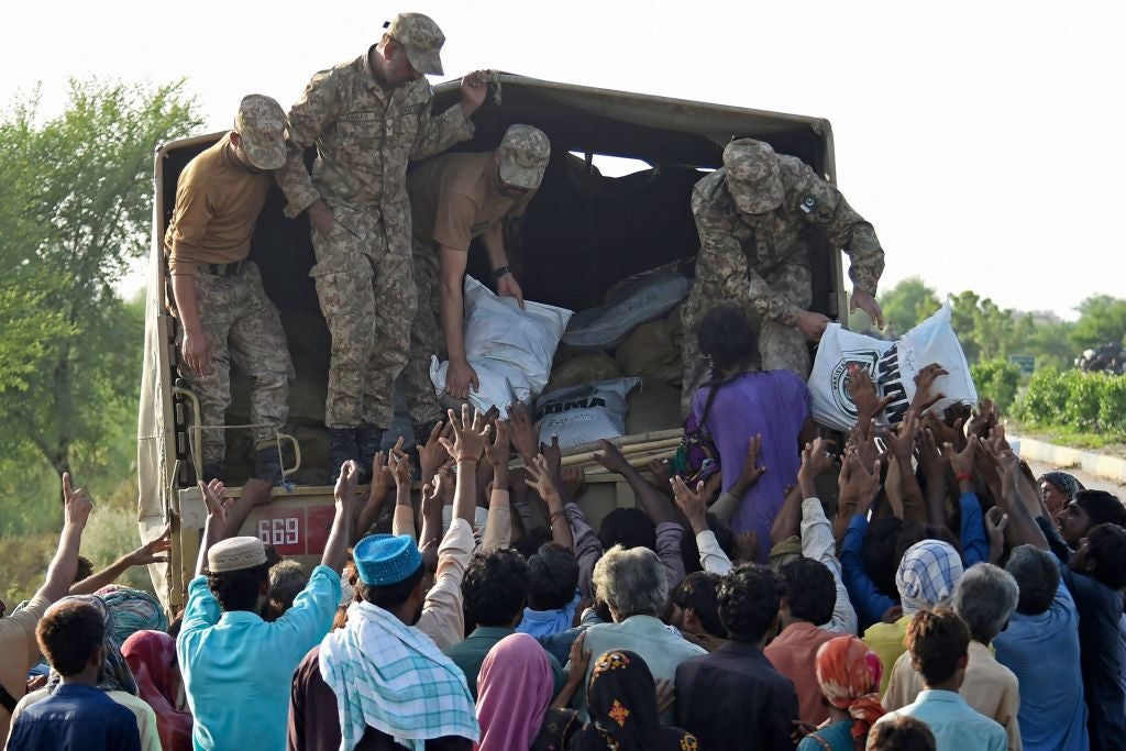 Army soldiers distribute relief food bags to flood-affected people in Shikarpur of Sindh province on August 28, 2022. (Photo: ASIF HASSAN/AFP, Getty Images)
