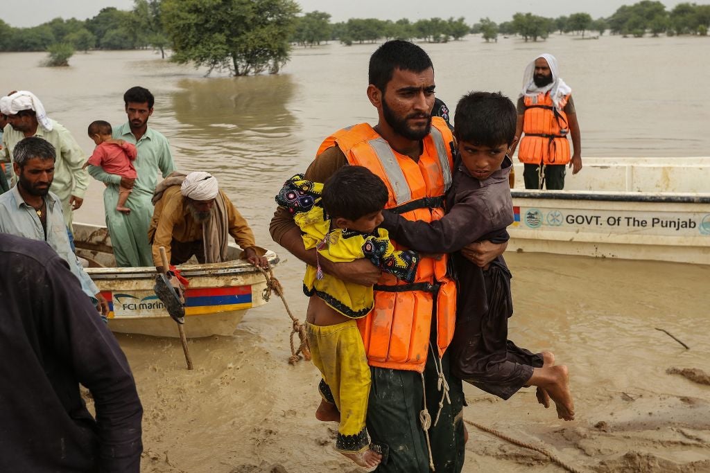 Rescue workers help evacuate people from their flood-hit homes following heavy monsoon rains in Rajanpur district of Punjab province on August 27, 2022. (Photo: SHAHID SAEED MIRZA/AFP, Getty Images)