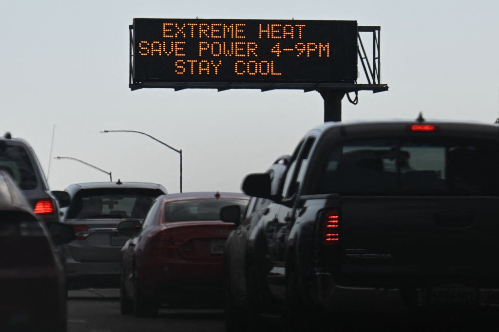 Vehicles drive past a sign on the 110 Freeway warning of extreme heat and urging energy conservation during a heat wave in downtown Los Angeles, California on September 2, 2022.  (Photo: Patrick T. FALLON / AFP, Getty Images)