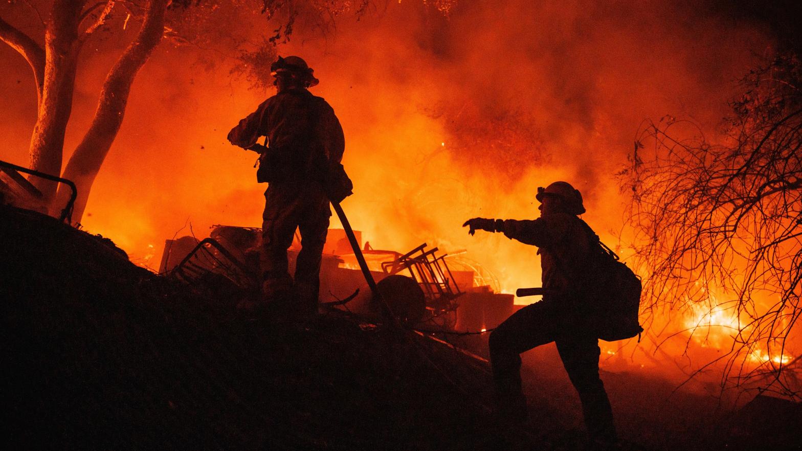 Firefighters coordinate efforts at a burning property while battling the Fairview Fire on Monday, Sept. 5, 2022, near Hemet, California.  (Photo: Ethan Swope, AP)