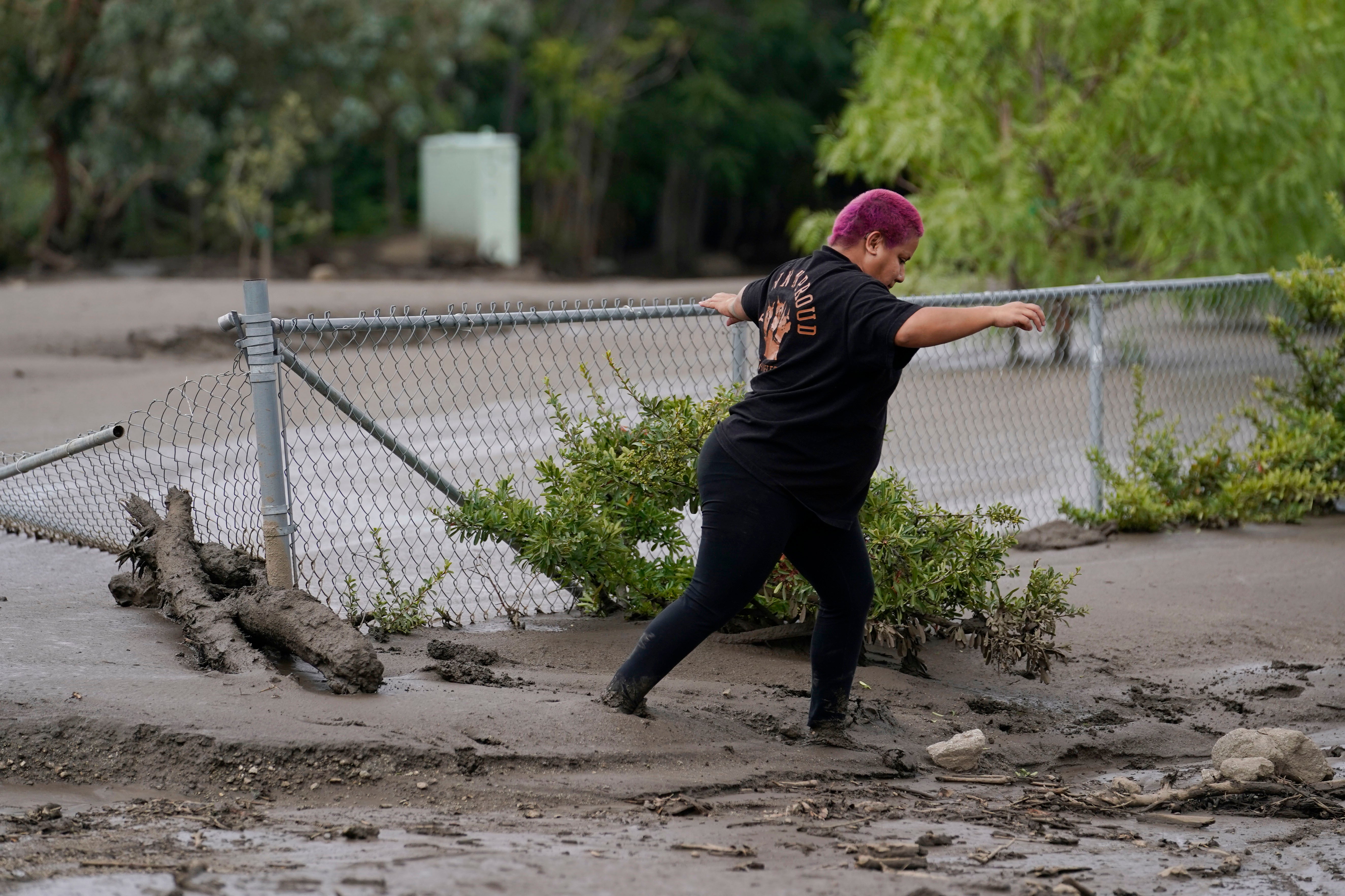 Local resident Perla Halbert walks through the mud along her driveway in the aftermath of a mudslide on Tuesday, Sept. 13, 2022, in Oak Glen, California.  (Photo: Marcio Jose Sanchez, AP)