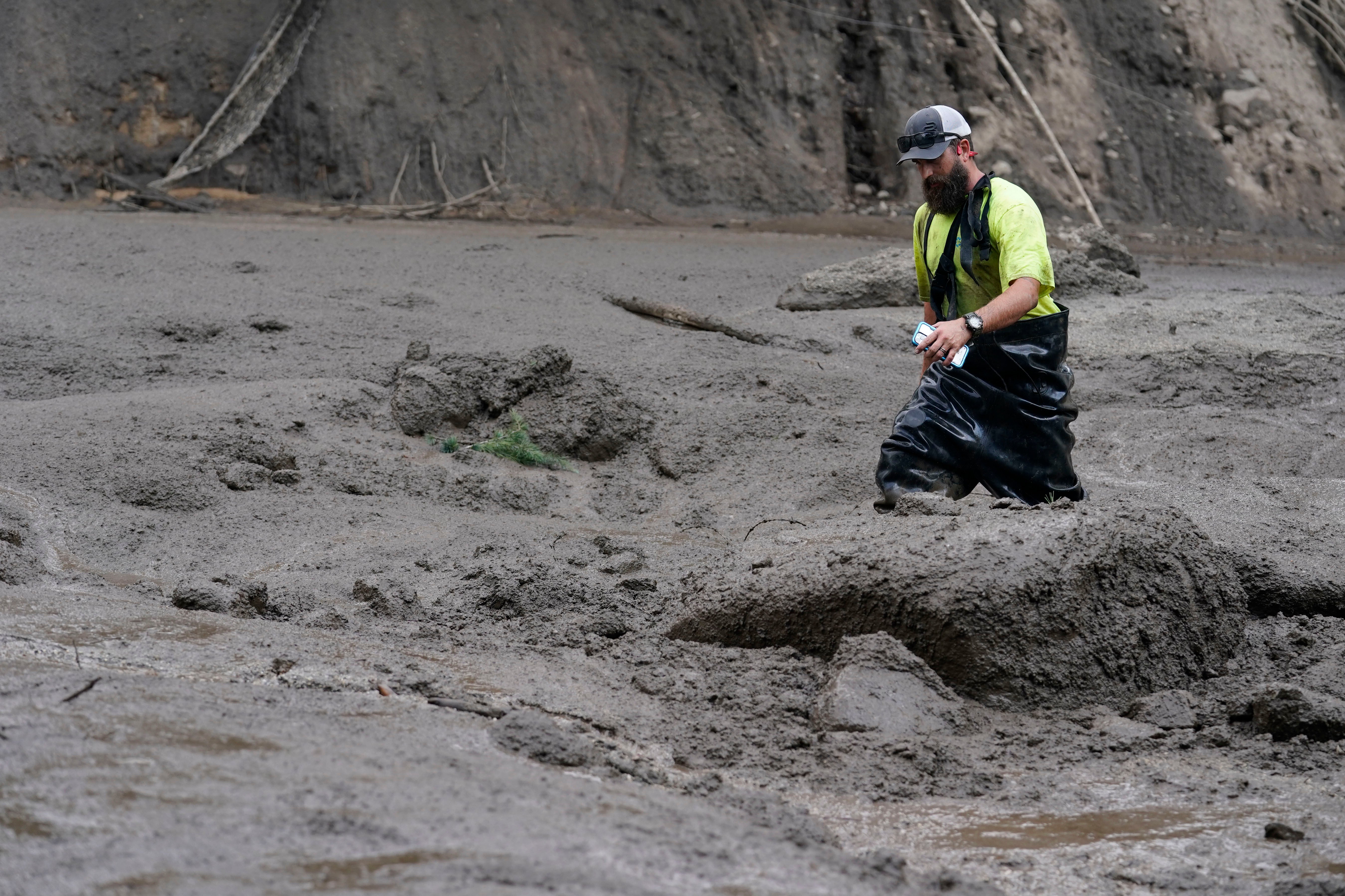 A worker with the Yucaipa Valley Water District threads through knee-deep mud while repairing a reservoir used as a drinking source in the aftermath of a mudslide, on Tuesday, Sept. 13, 2022, in Oak Glen, California.  (Photo: Marcio Jose Sanchez, AP)