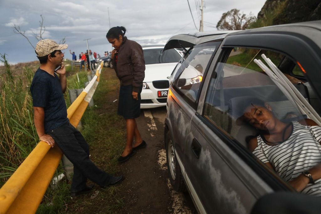  Family members gather while attempting to speak by phone with another family member along a roadside near the top of a mountain, more than two weeks after Hurricane Maria swept through the island, on October 6, 2017 in Orocovis, Puerto Rico. (Photo: Mario Tama, Getty Images)