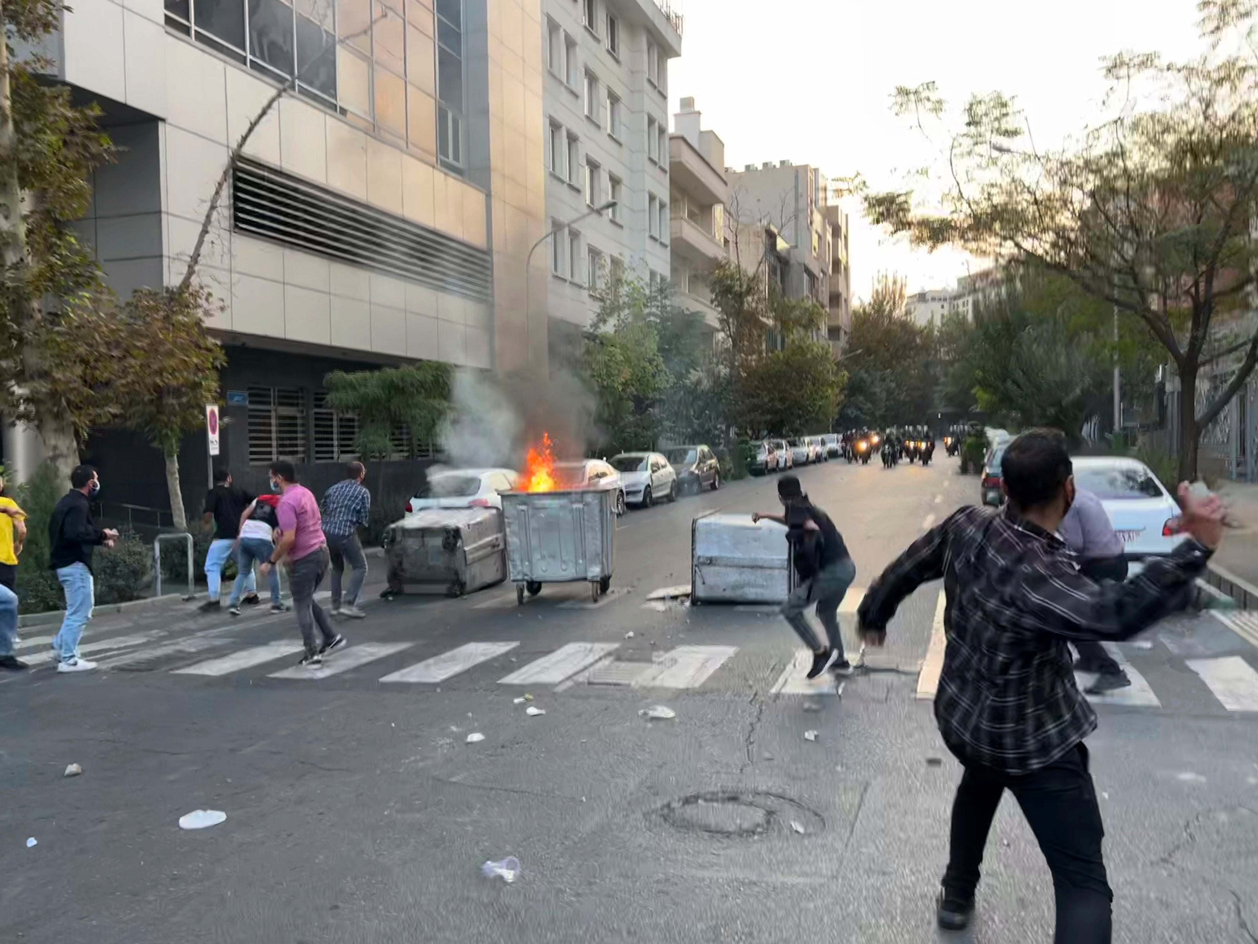 In this Tuesday, Sept. 20, 2022, photo taken by an individual not  employed by the Associated Press and obtained by the AP outside Iran,  protesters throw stones at anti-riot police during a protest over the  death of a young woman who had been detained for violating the country's  conservative dress code, in downtown Tehran, Iran. (Photo: AP Photo, AP)