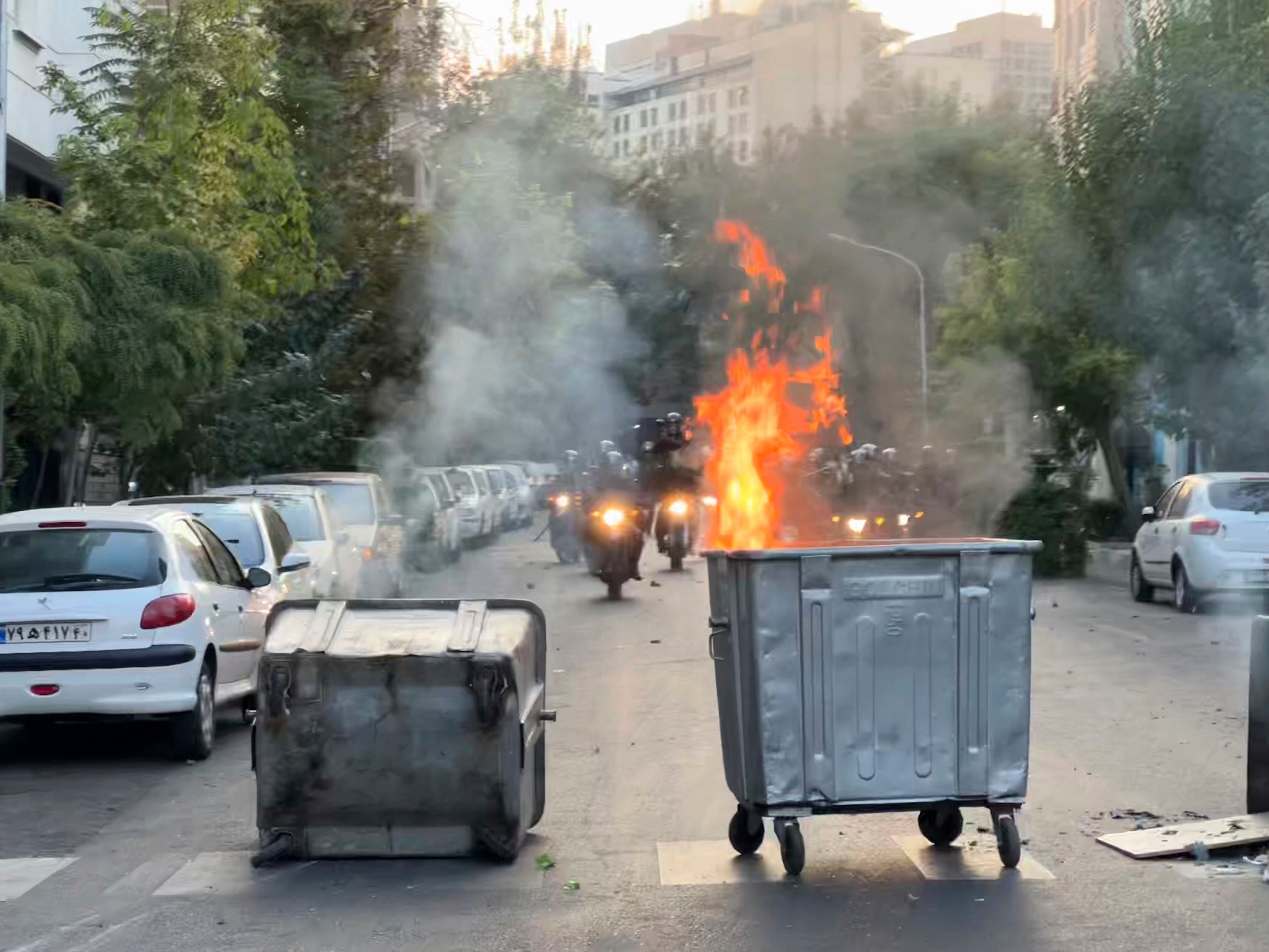 In this Tuesday, Sept. 20, 2022, photo taken by an individual not  employed by the Associated Press and obtained by the AP outside Iran, a  trash bin is burning as anti-riot police arrive during a protest over  the death of a young woman who had been detained for violating the  country's conservative dress code, in downtown Tehran, Iran. (Photo: AP Photo, AP)