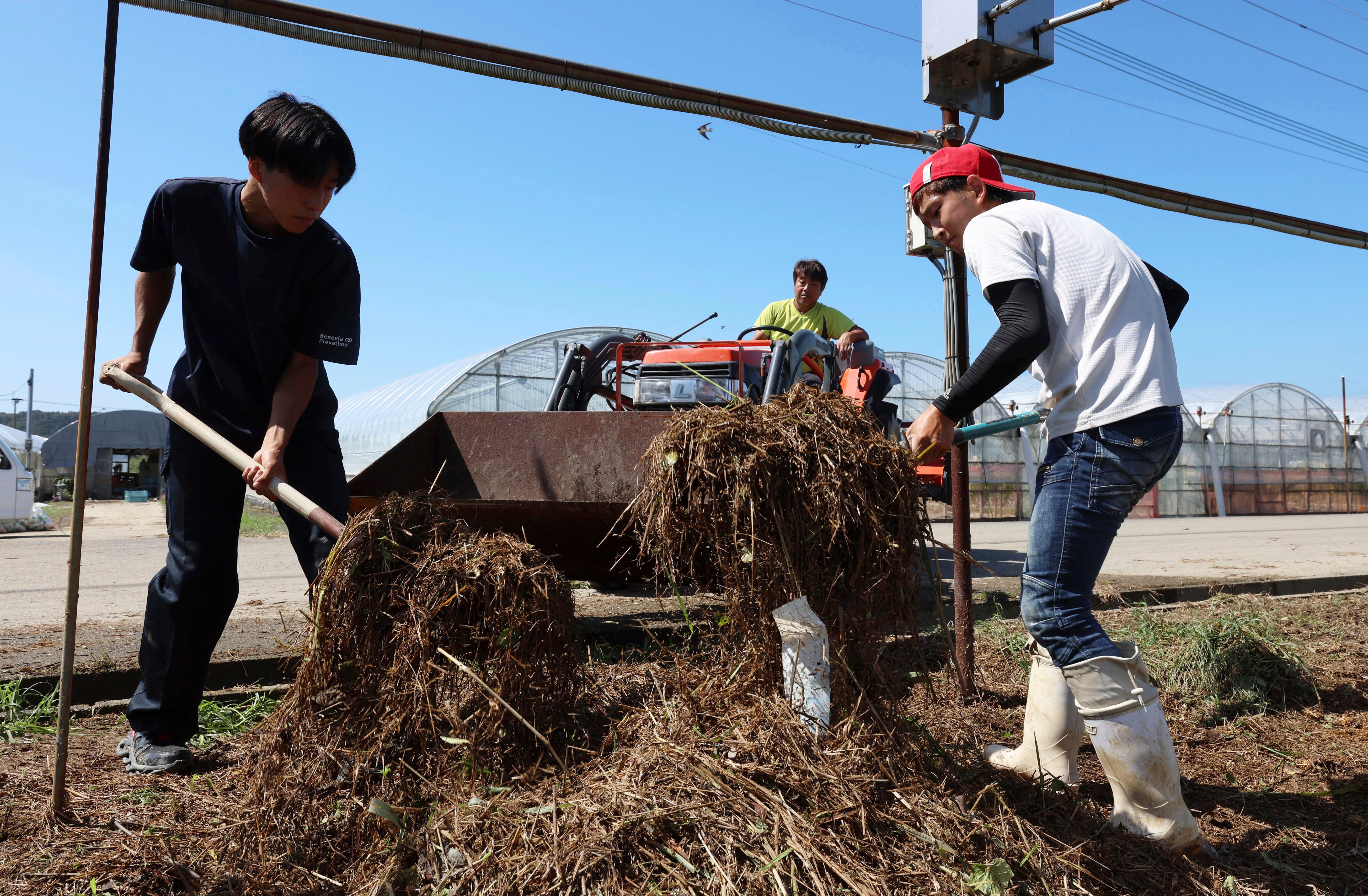 People clean up a farmland that was flooded by the storm.  (Photo: The Yomiuri Shimbun, AP)