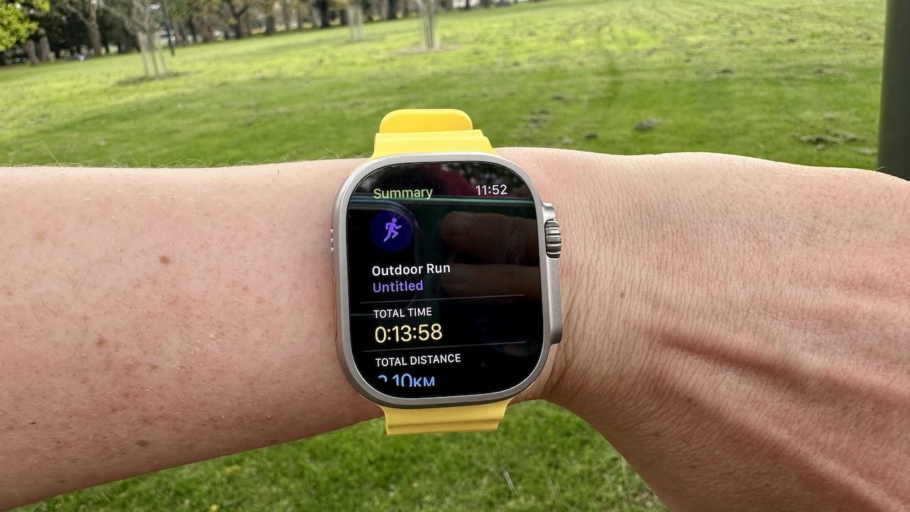 An Apple Watch saying someone ran 2kms in 13 minutes in front of a lawn