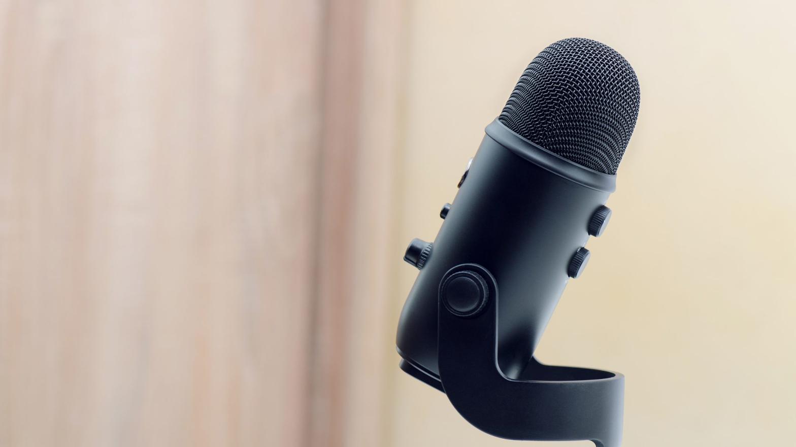 Black Microphone On Wooden Background With Soft Blue Effect