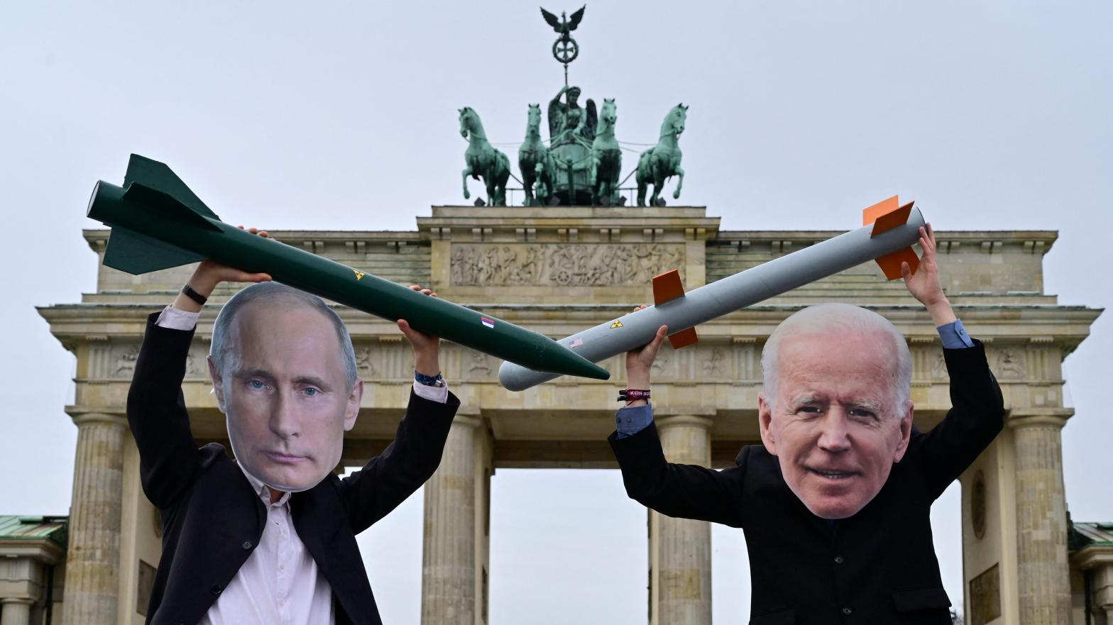 Peace activists wearing masks of Russian President Vladimir Putin (L) and newly elected US President Joe Biden pose with mock nuclear missiles in front of Berlin's landmark the Brandenburg Gate on January 29, 2021 in an action to call for more progress in nuclear disarmament. (Photo: John MacDougal, Getty Images)