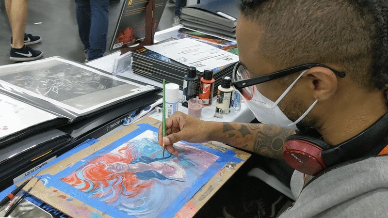 Marco Rudy brush-dips in and out of his acrylics as he reflects on work with big comic publishers and now creating his own independent work. (Gif: Kyle Barr/io9)