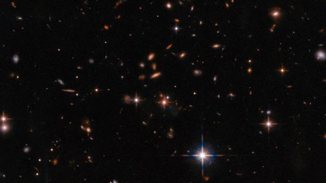 Webb Telescope Finds Polychrome Quasar Surrounded by Ancient Galaxies