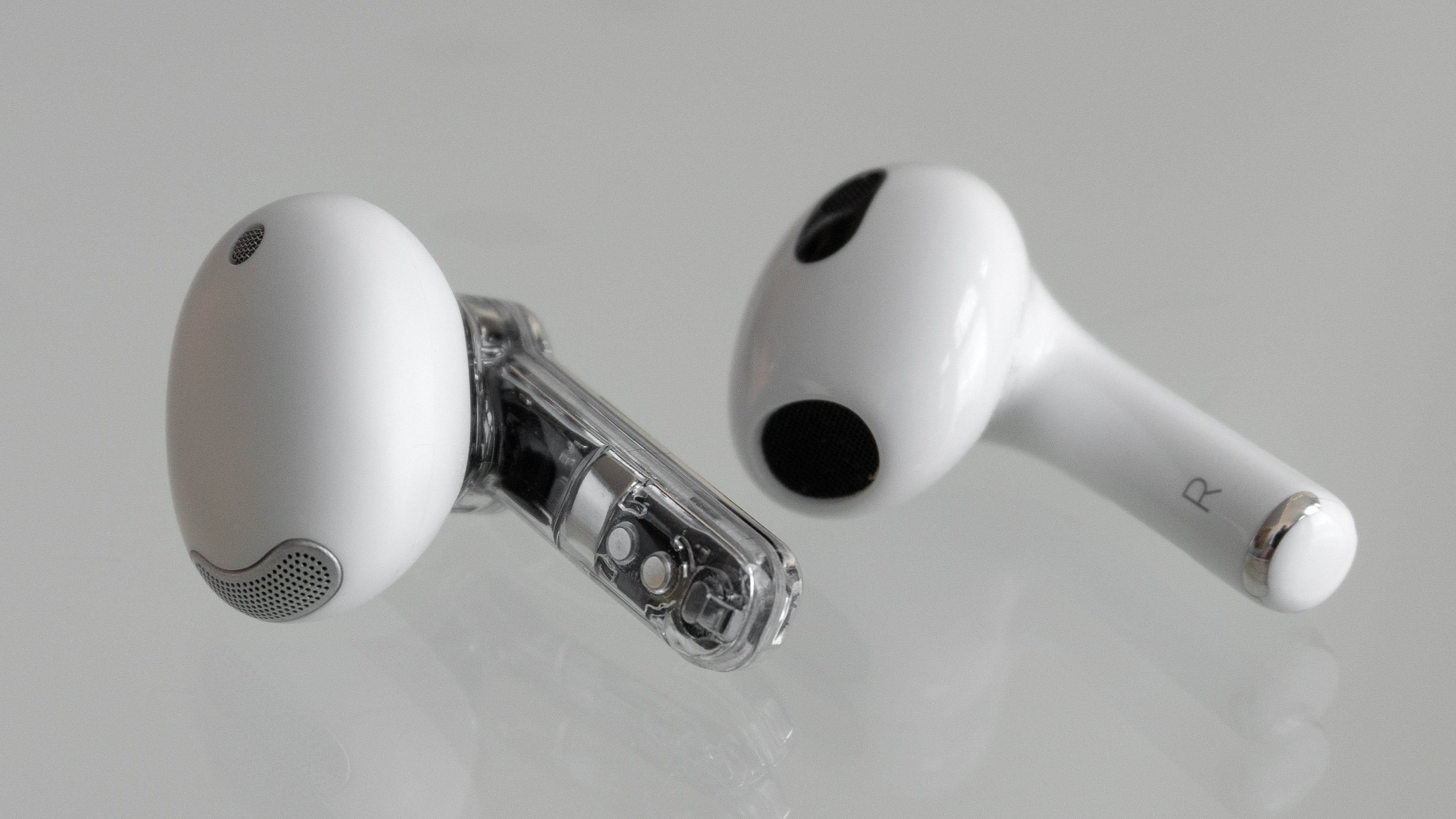 The Ear (stick) (left) compared to the third-gen AirPod (right) which are more or less identical in size. (Photo: Andrew Liszewski | Gizmodo)