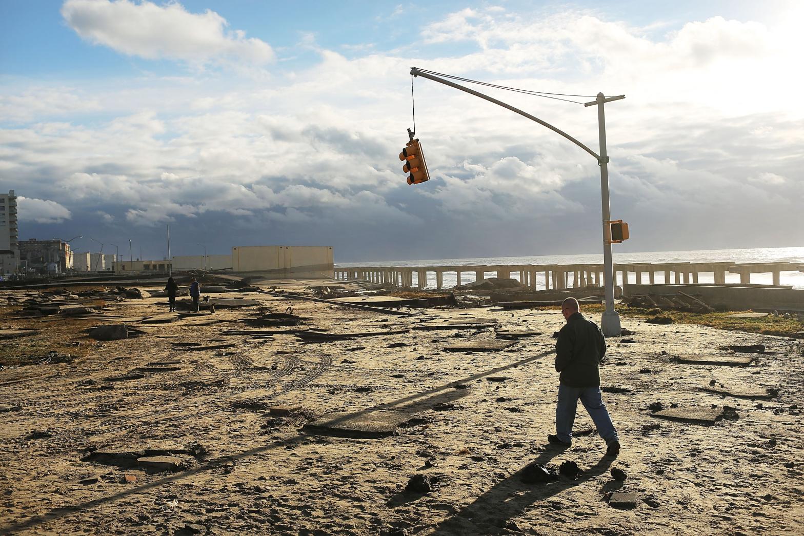 A man walks by the remains of part of the historic Rockaway boardwalk in New York City after large parts of it were washed away during Hurricane Sandy on October 31, 2012. (Photo: Spencer Platt, Getty Images)
