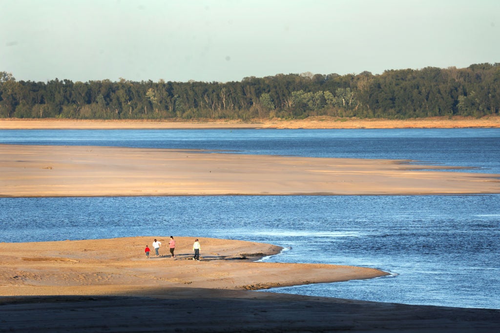 People walk across a sand bar exposed by low water on the Mississippi River on October 19, 2022 in Helena, Arkansas.  (Photo: Scott Olson, Getty Images)