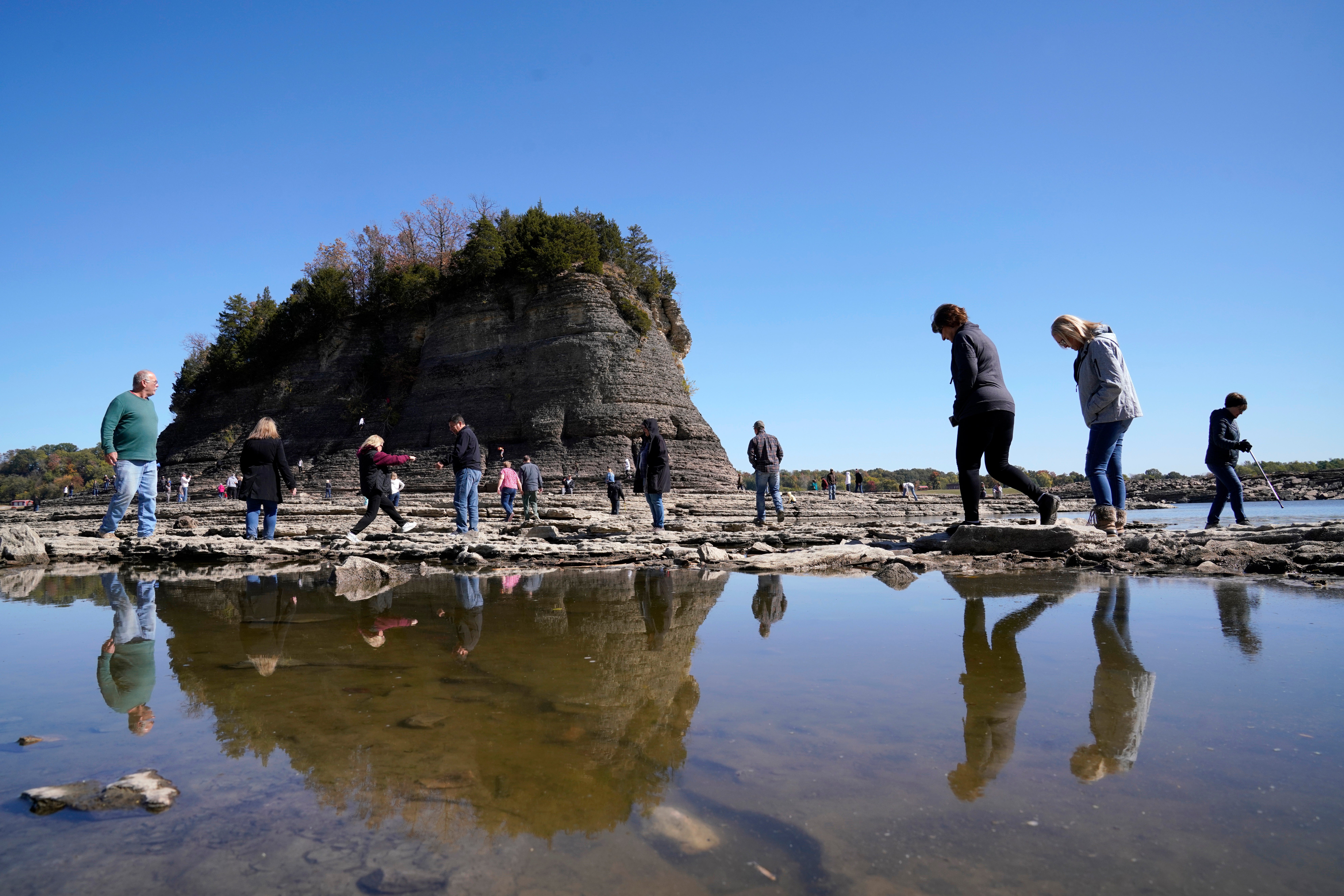 People walk to Tower Rock, an attraction normally surrounded by the Mississippi River and only accessible by boat, Oct. 19, 2022, in Perry County, Mo. (Photo: Jeff Roberson,   (AP))